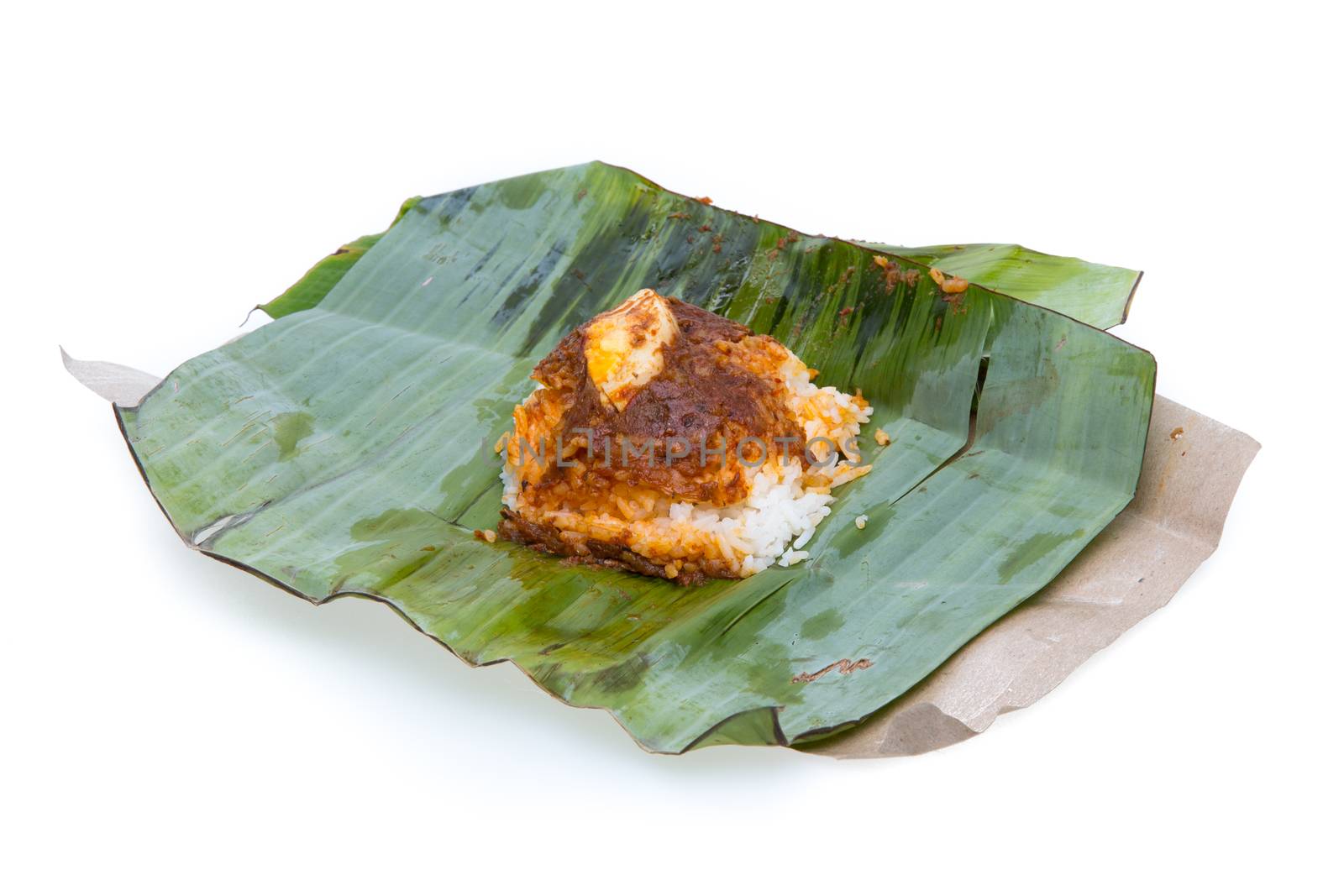 nasi lemak, a traditional malay curry paste rice dish served on a banana leaf