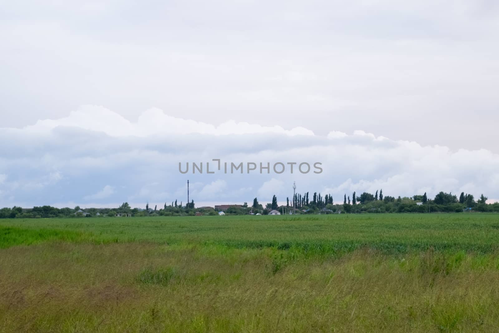 Cloudy landscape, the village before the rain, visible large cumulus clouds and clouds over the village.