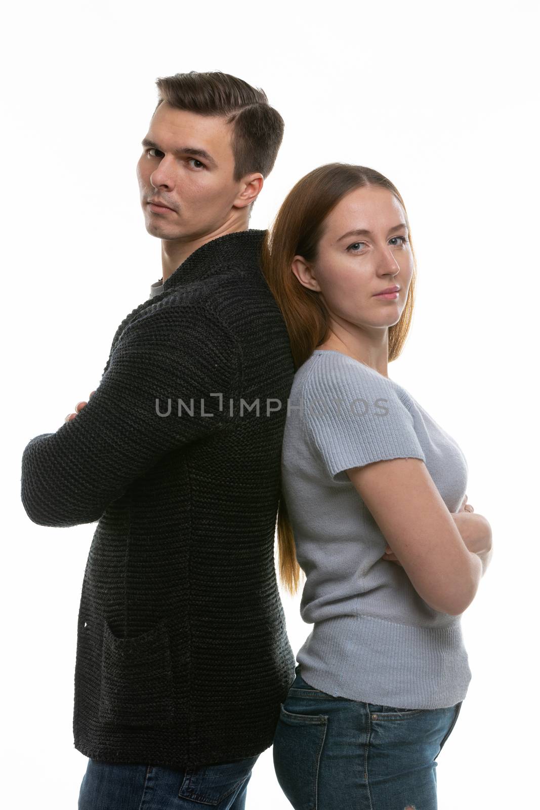 A couple with big problems stand with their backs to each other and look into the frame