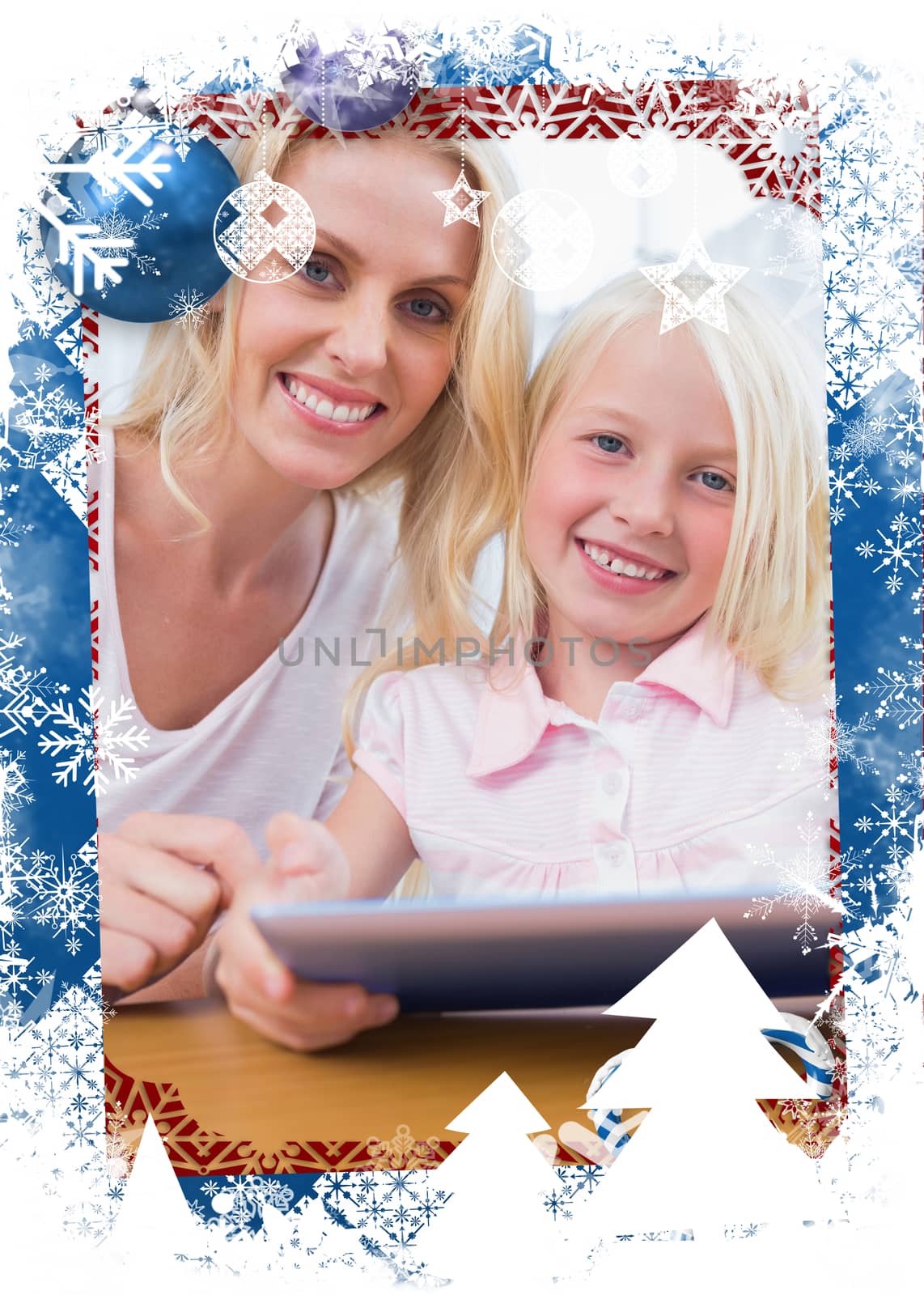 Mother using tablet pc with her daughter against christmas themed frame