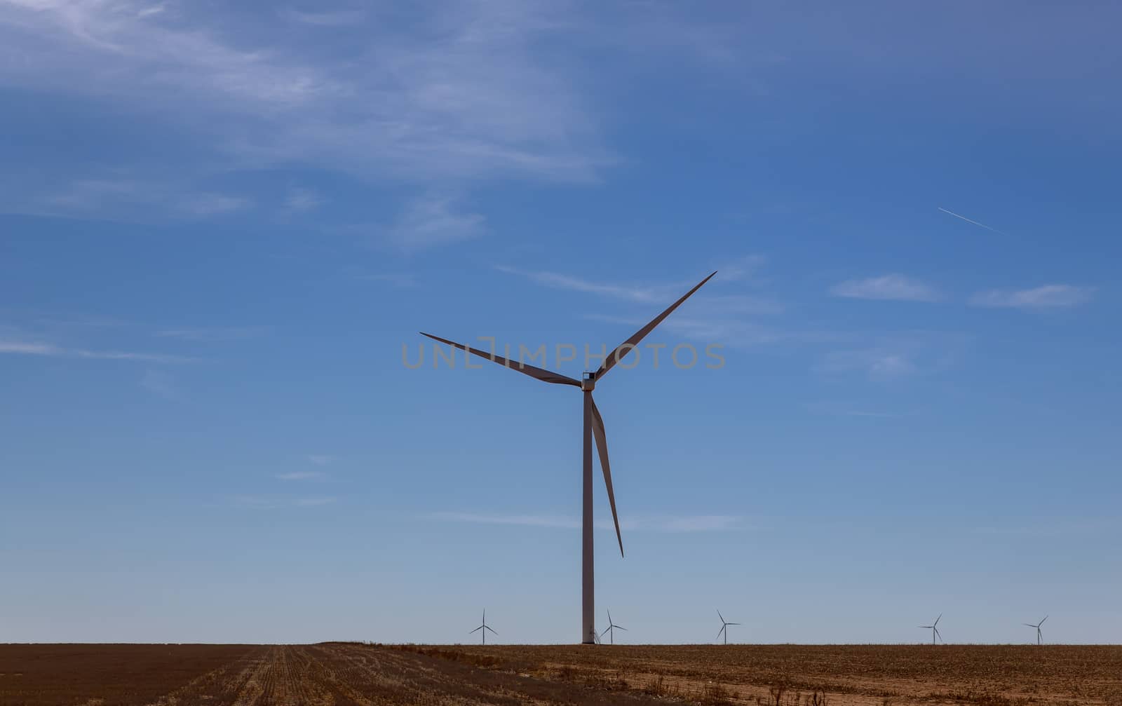 A windmill with modern wind turbines in the located in West Texas sunny day