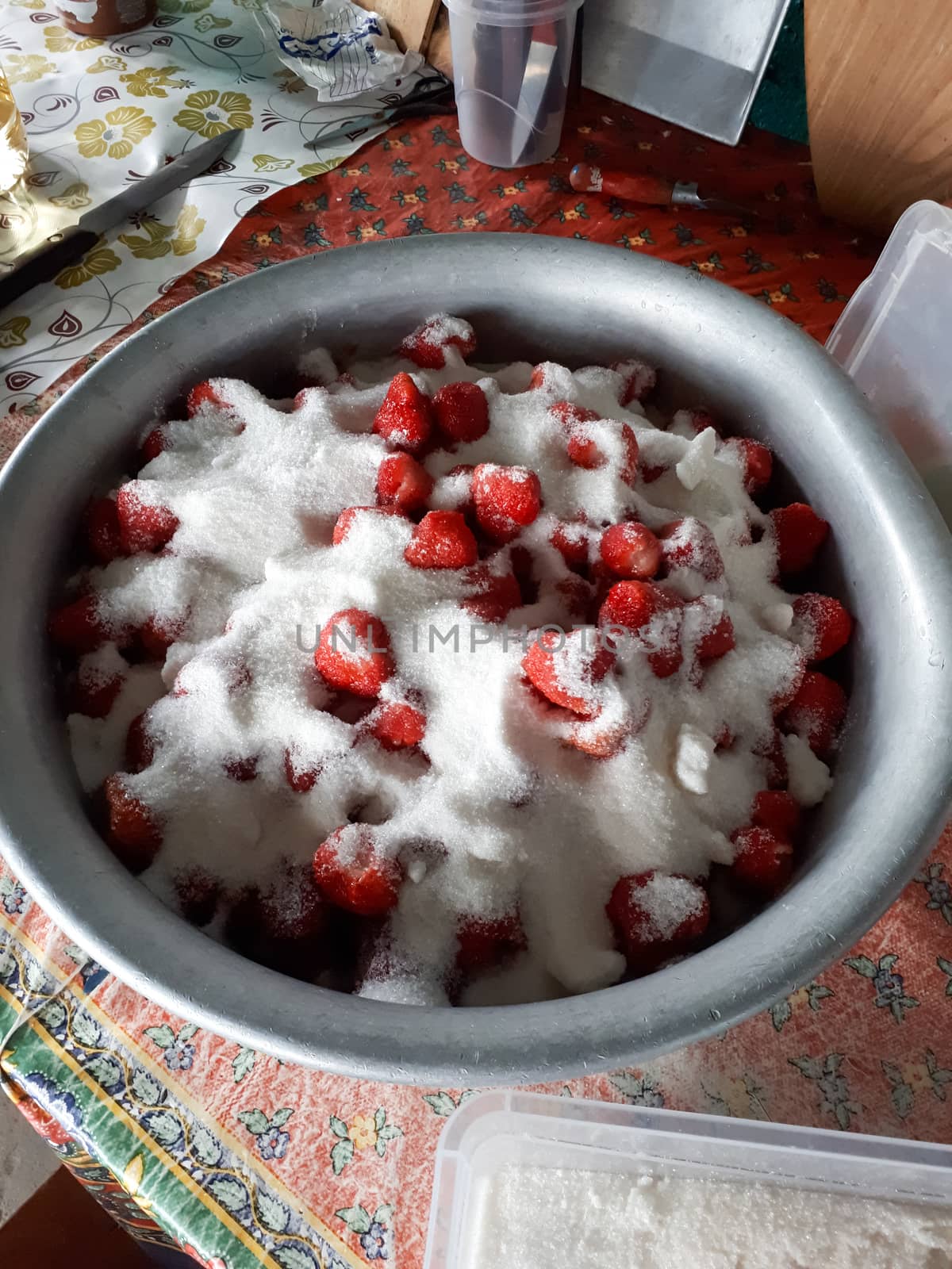 Strawberry berries with sugar in a basin. Harvesting berries for cooking.