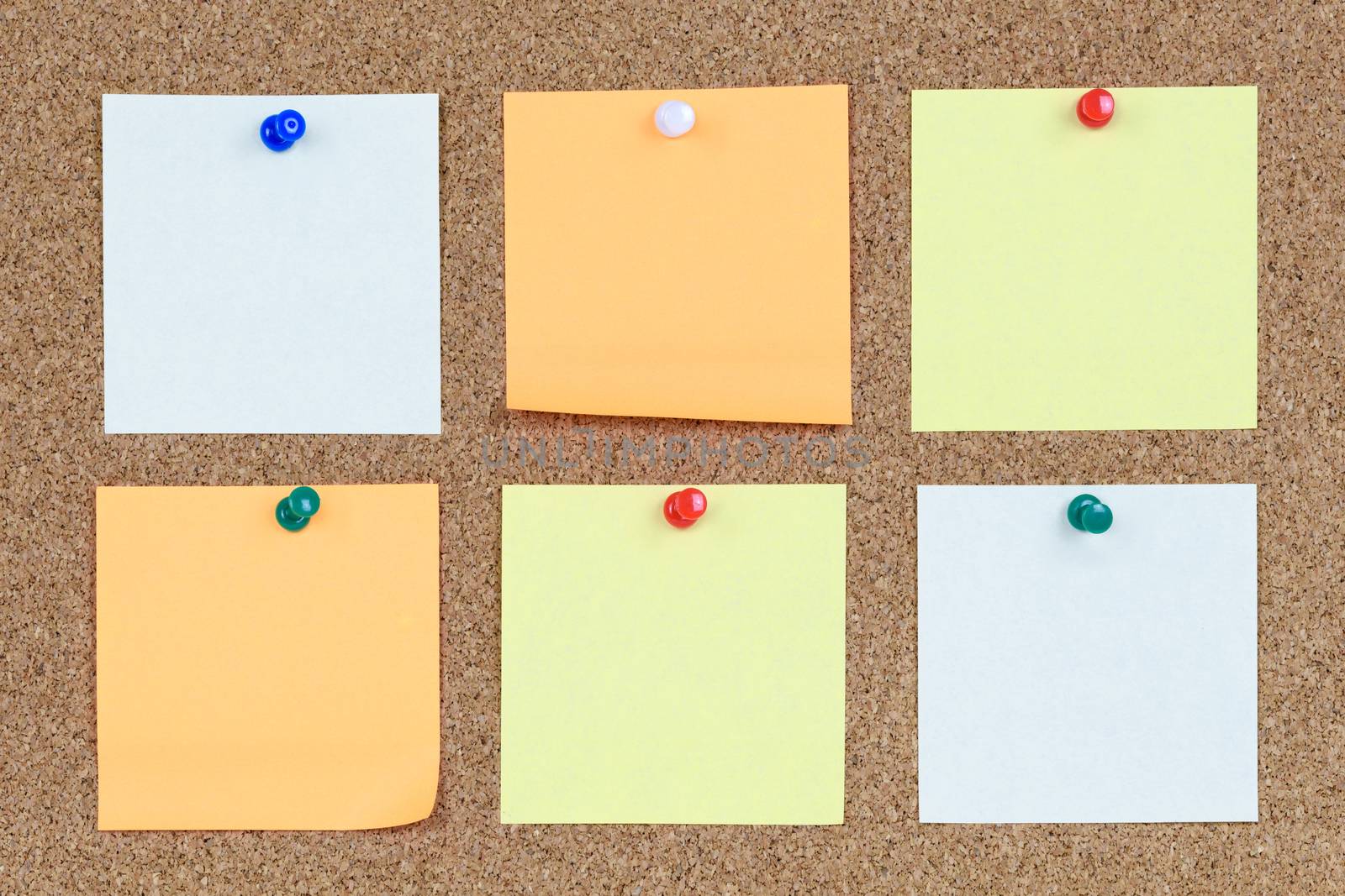 Six various and blank notes on an office cork bulletin board.