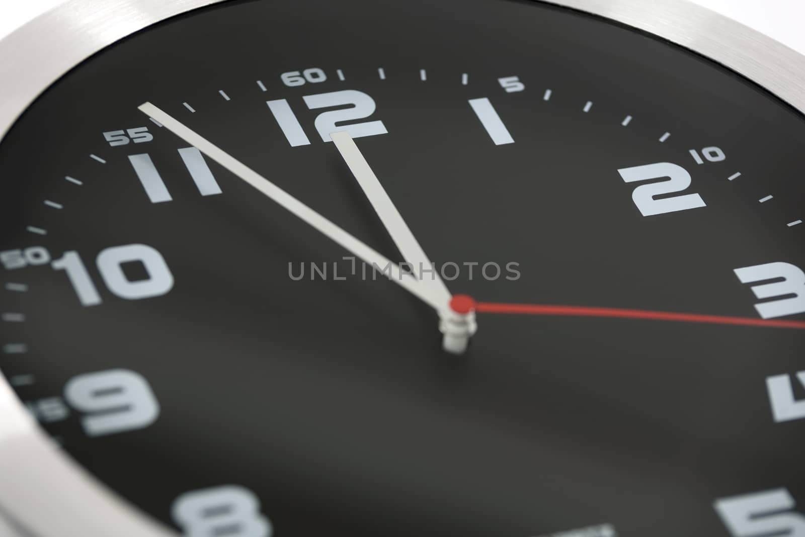 Close up to generic black and silver wall clock showing at the eleventh hour 