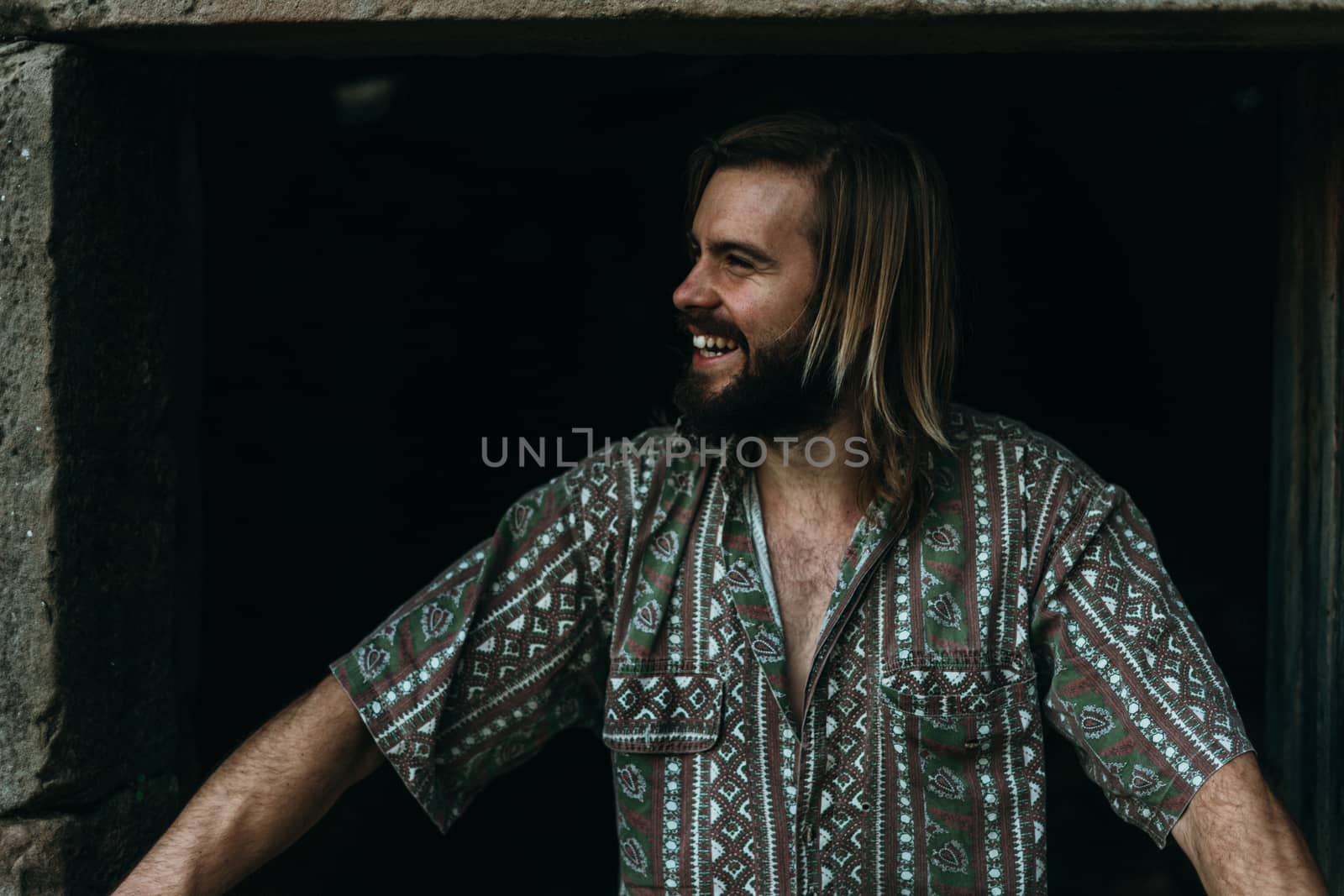 portrait of young man with a beard at the farmhouse door