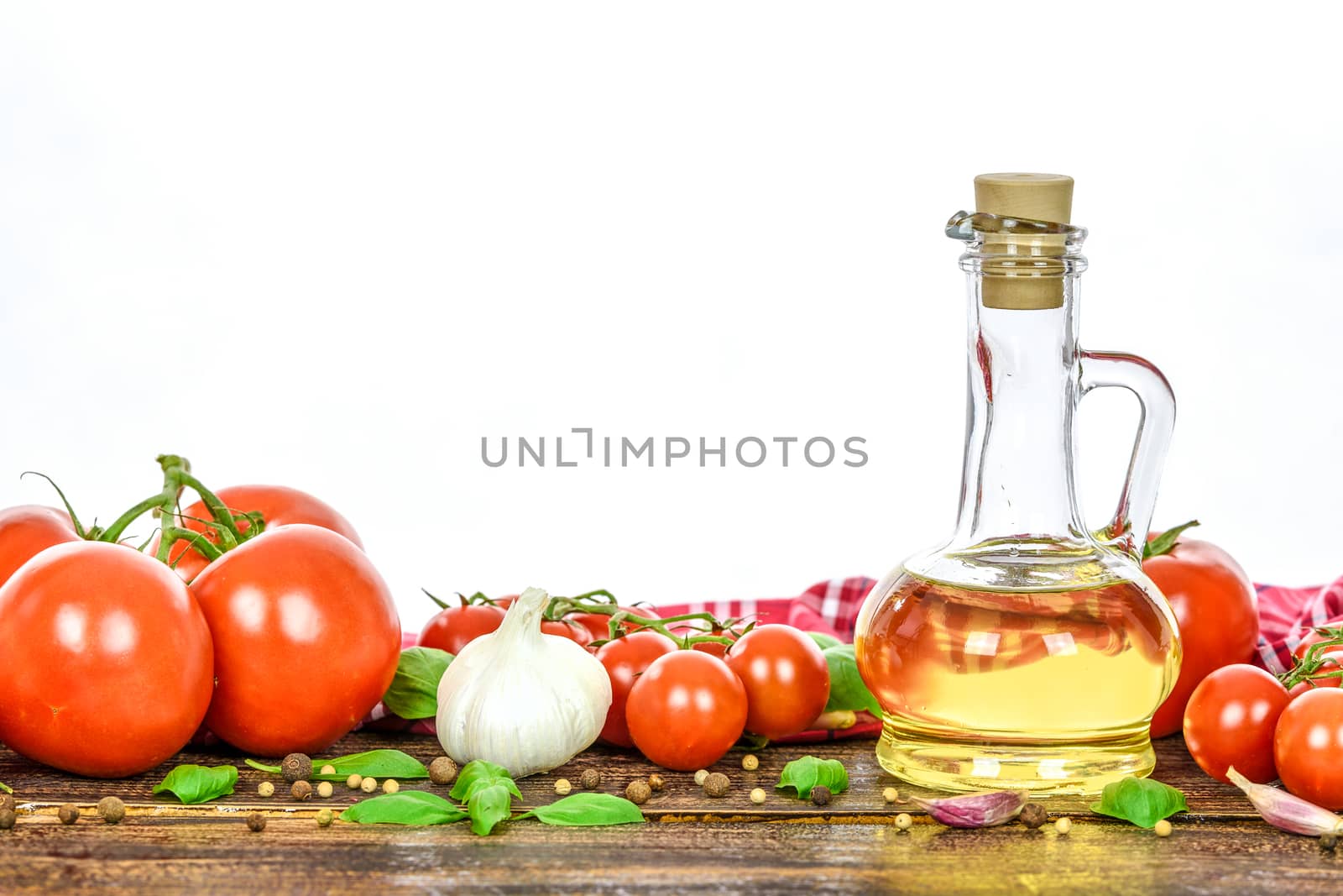 Classic ingredients of Italian cuisine: basil, garlic, olive oil, pepper on a wooden vintage table.