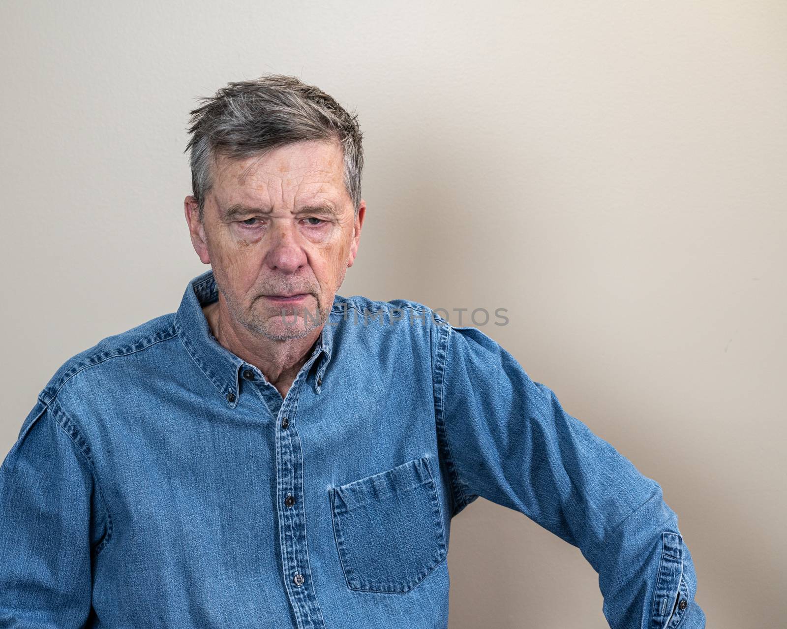 Head and shoulders portrait of a senior caucasian man unshaven and facing camera