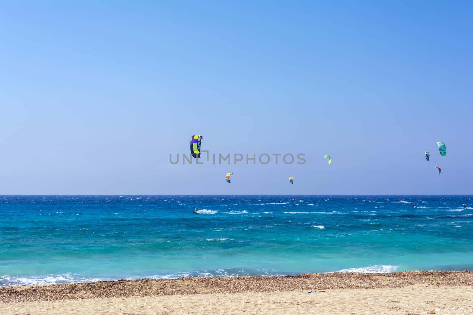 Agios Ioannis beach in Lefkas island Greece. Colorful power kites span across the sky from kite-surfers.
