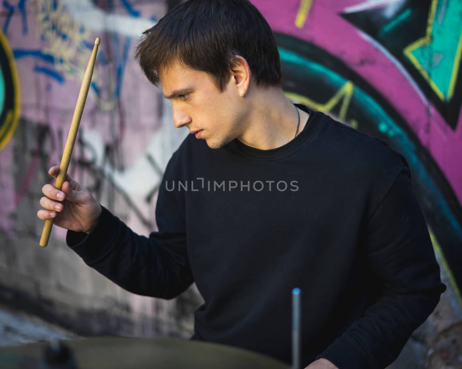 Young man playing drums in an underground environment