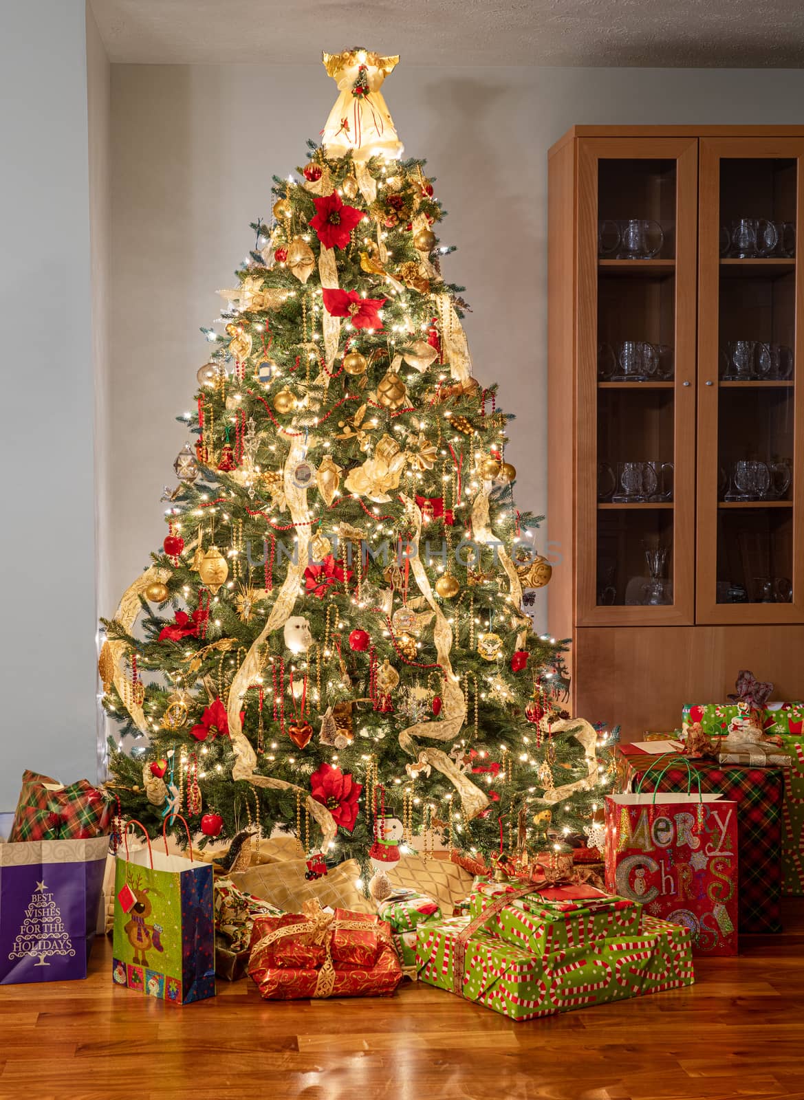 Colorful christmas tree surrounded by wrapped presents and gifts by steheap