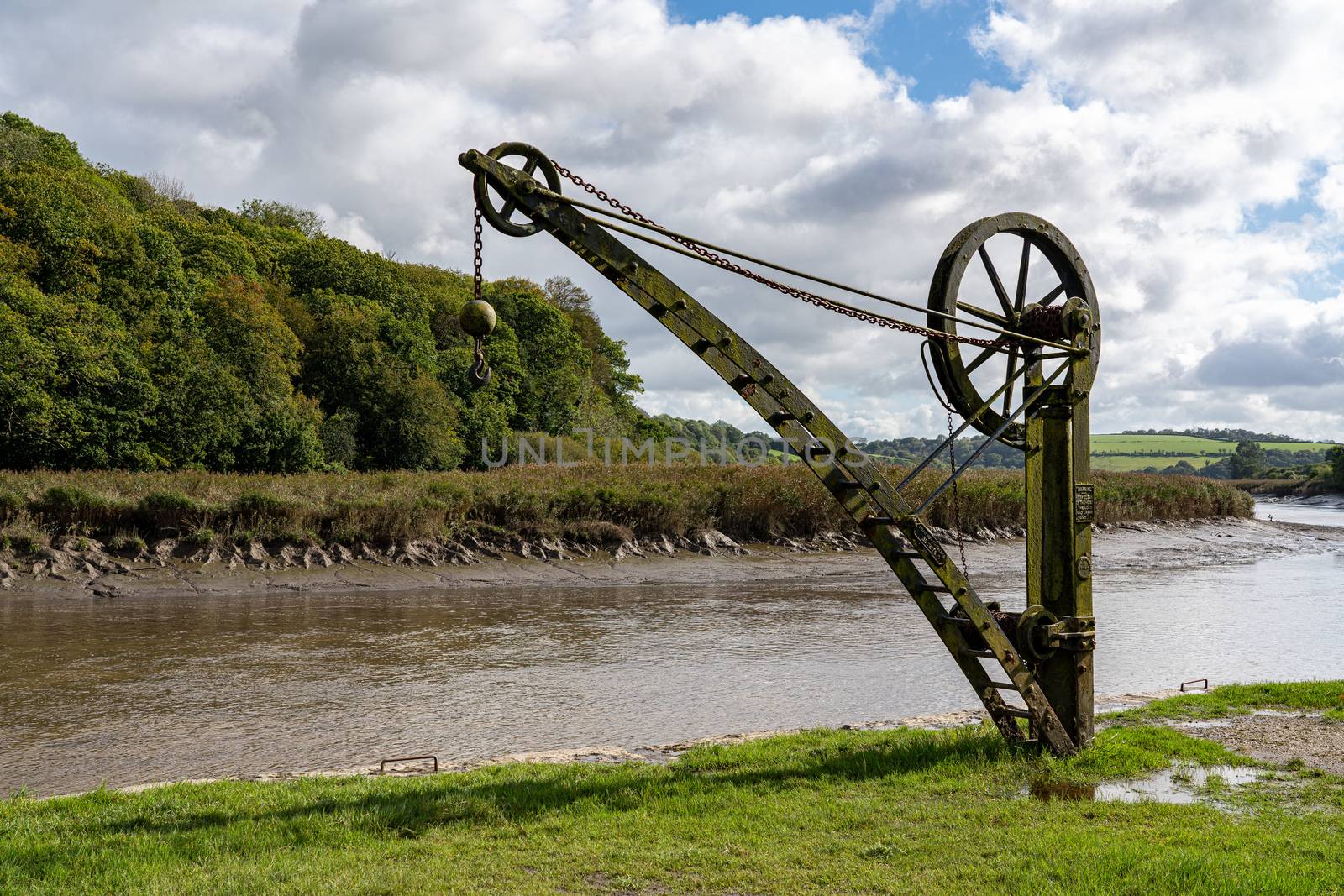 Rusty old metal winch or crane for cargo by the tidal River Tamar at Cotehele in Devon