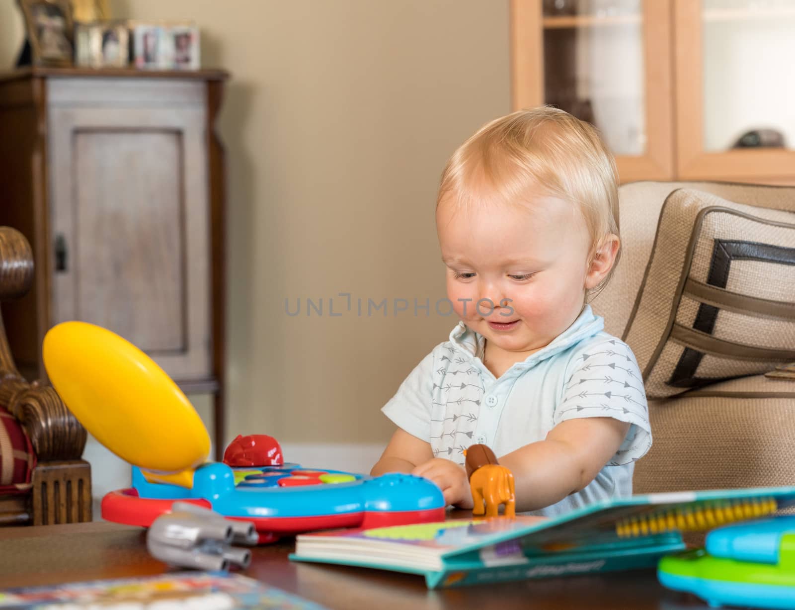 Infant caucasian boy playing with toy computer by steheap