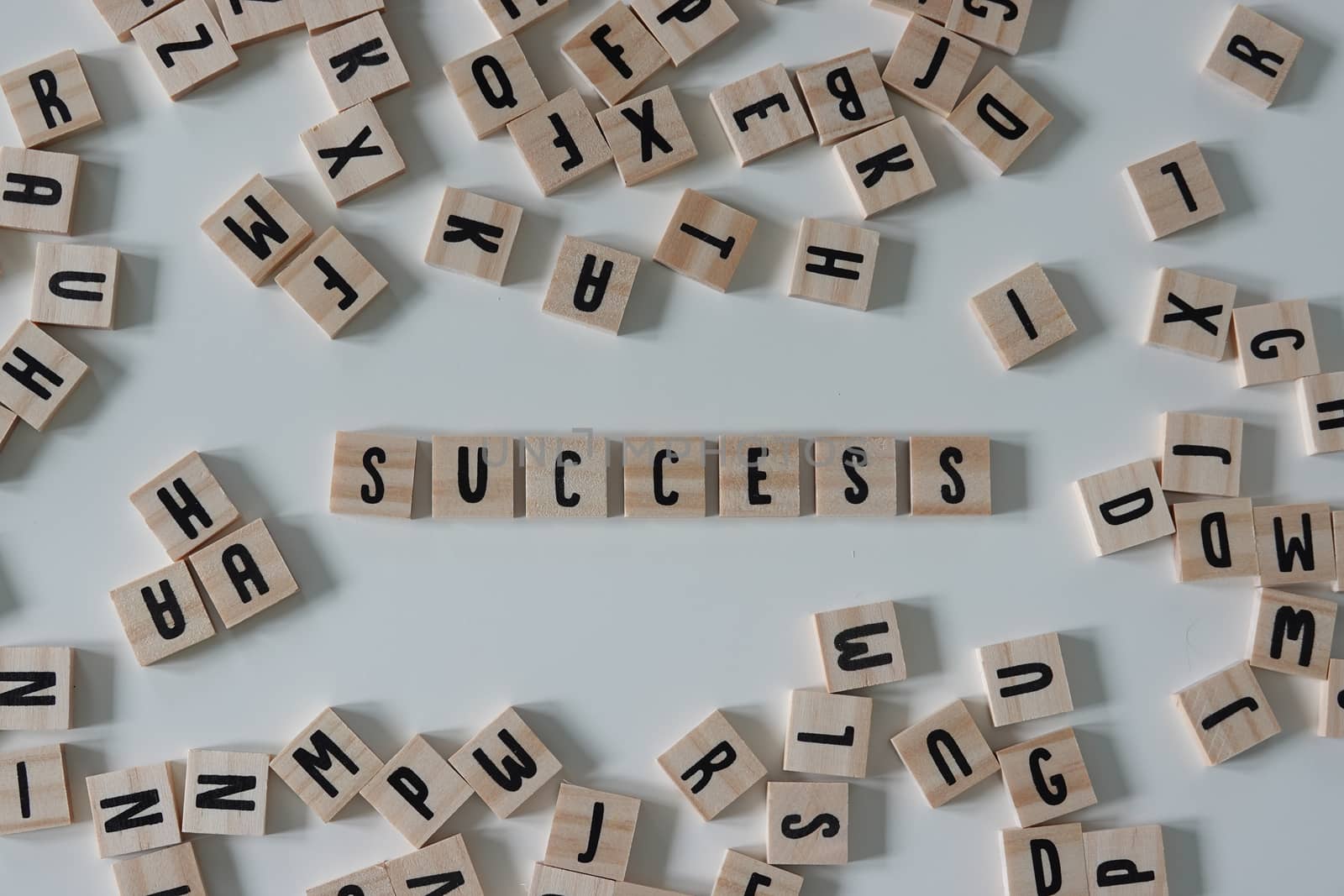 Success written in wooden letter tiles on a white background by Jshanebutt