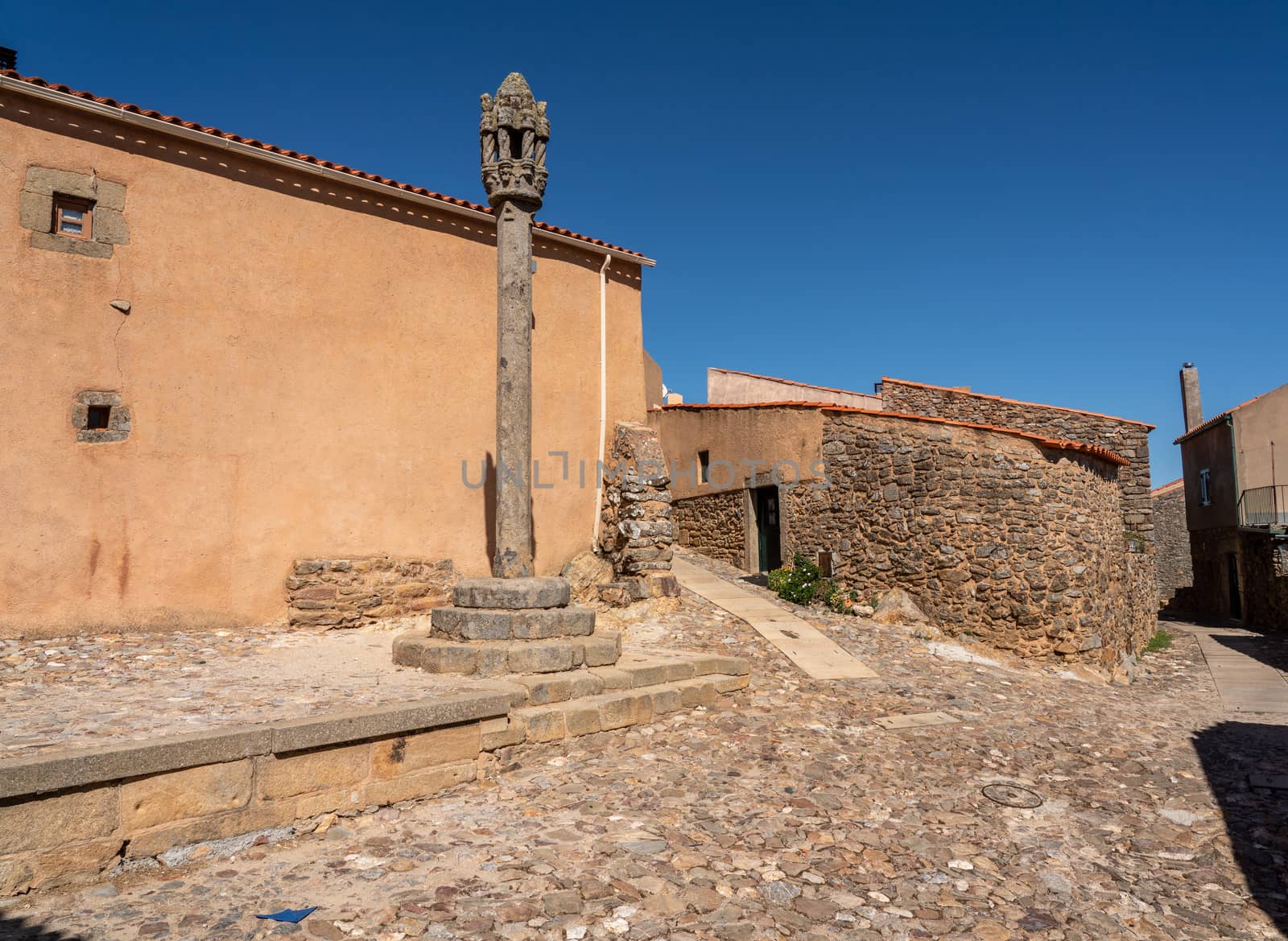 Old carved stone pillory column by narrow streets in the ancient town of Castelo Rodrigo in Portugal