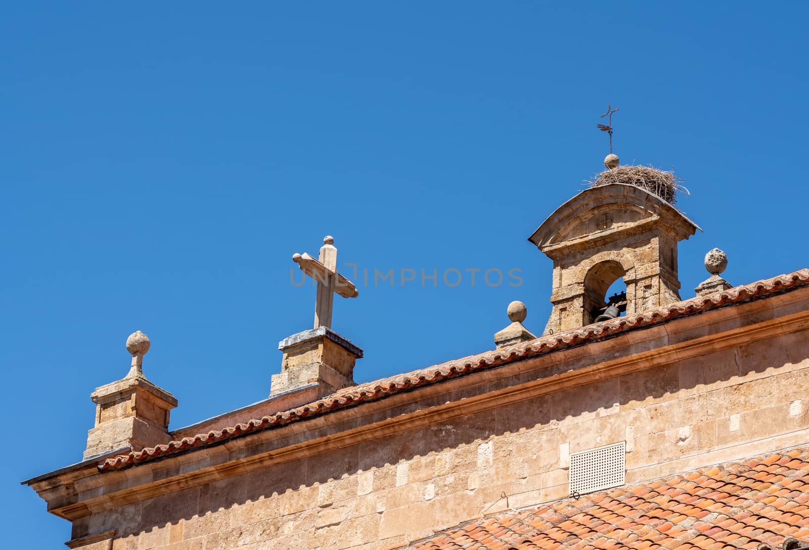 Detail of the bell tower and stork bird nest on the roof of San Pablo church in Salamanca Spain