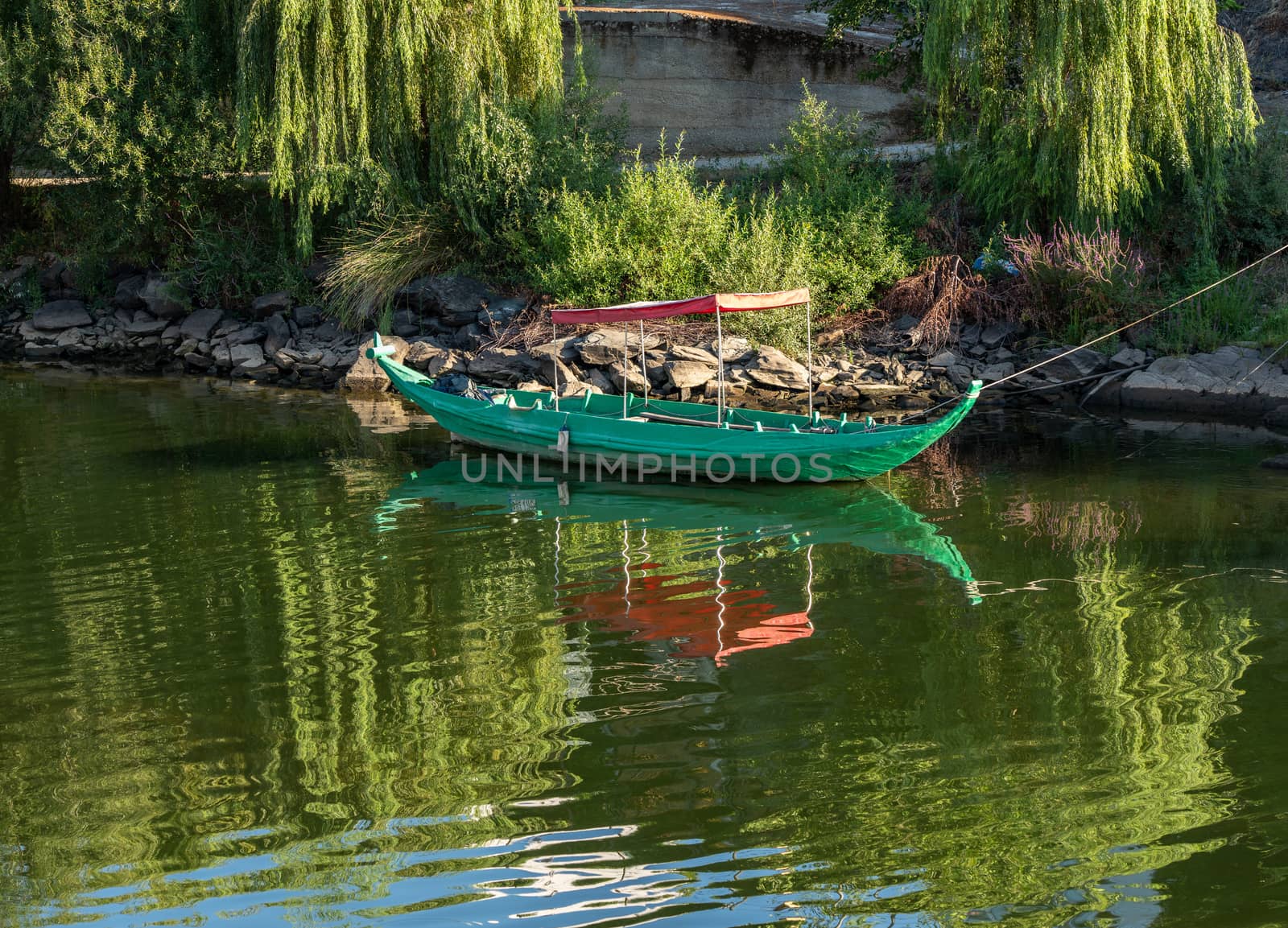 Fishing or rowing boat anchored in the calm waters on the bank of the River Douro in Portugal