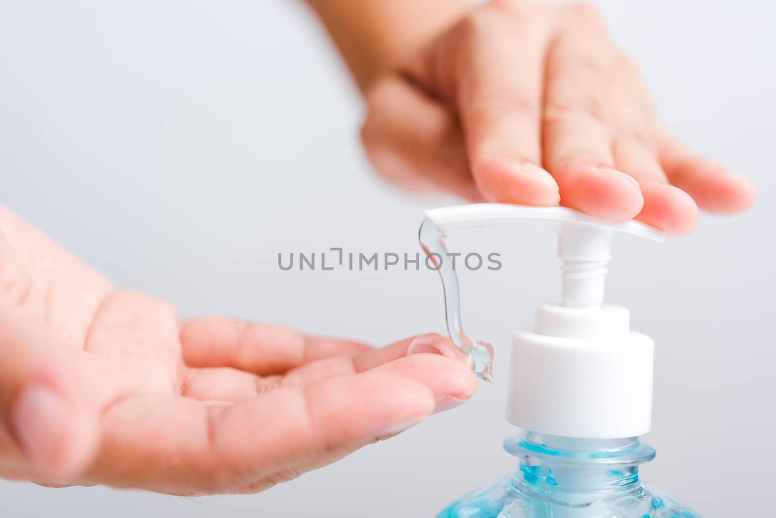 Close up Asian young woman applying press dispenser sanitizer alcohol gel pump to hand wash cleaning, hygiene prevention COVID-19 or coronavirus protection concept, isolated on white background