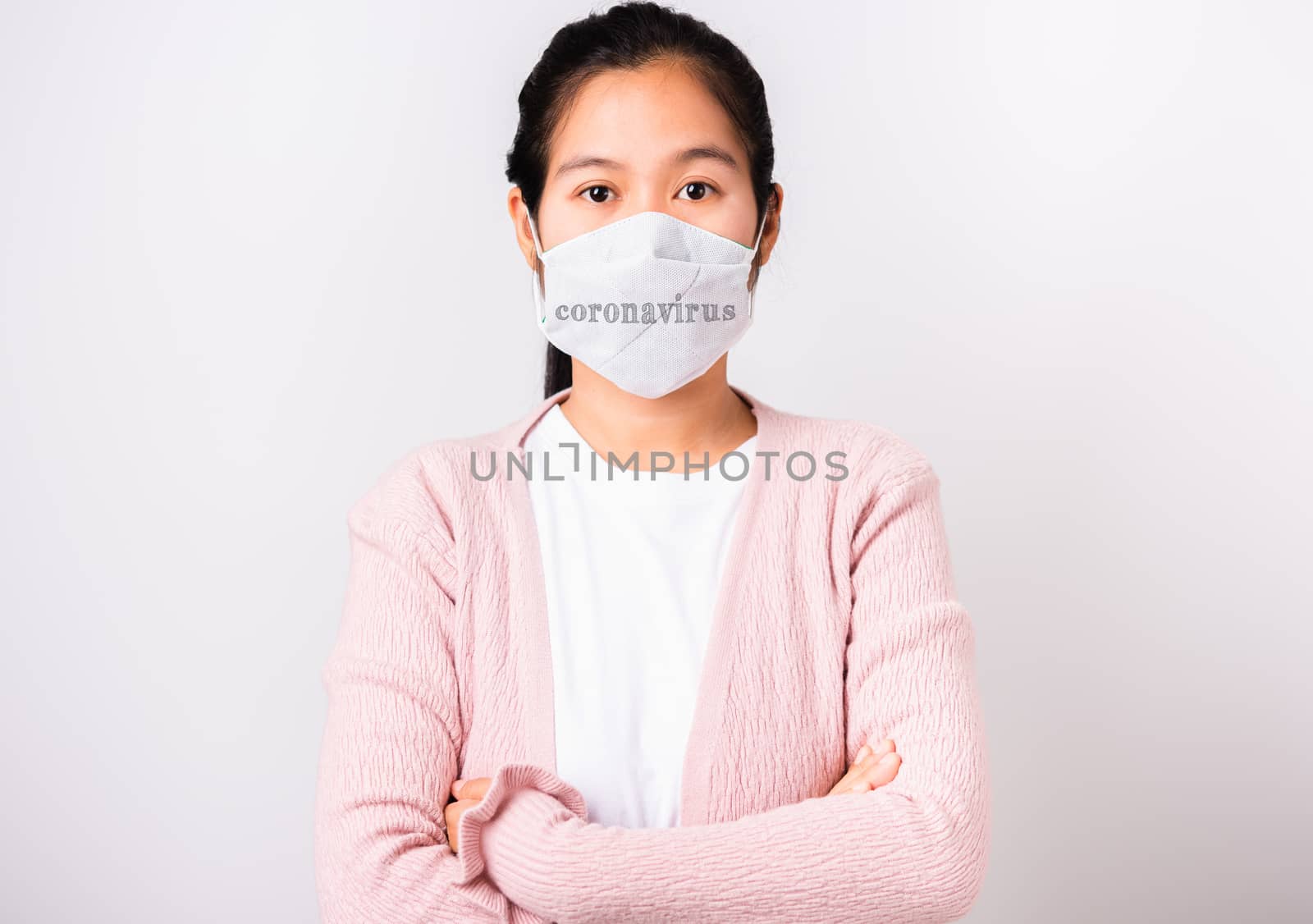 Asian beautiful woman wearing protection face mask against coronavirus standing crossed arm, studio shot isolated on white background with copy space, COVID-19 or corona virus concept