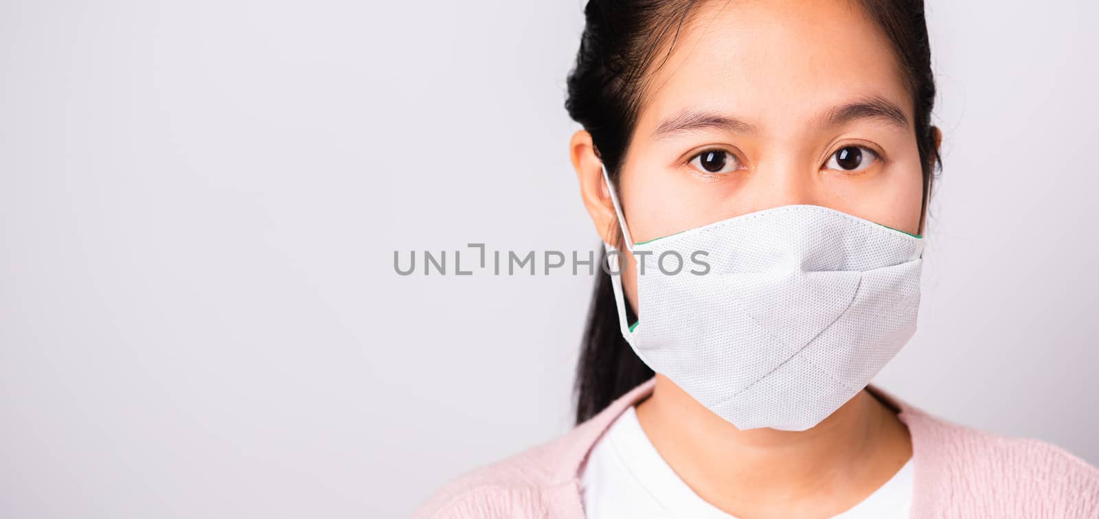 Asian beautiful woman wearing protection face mask against coronavirus her looking to camera, studio shot isolated on white background with copy space, COVID-19 or corona virus concept