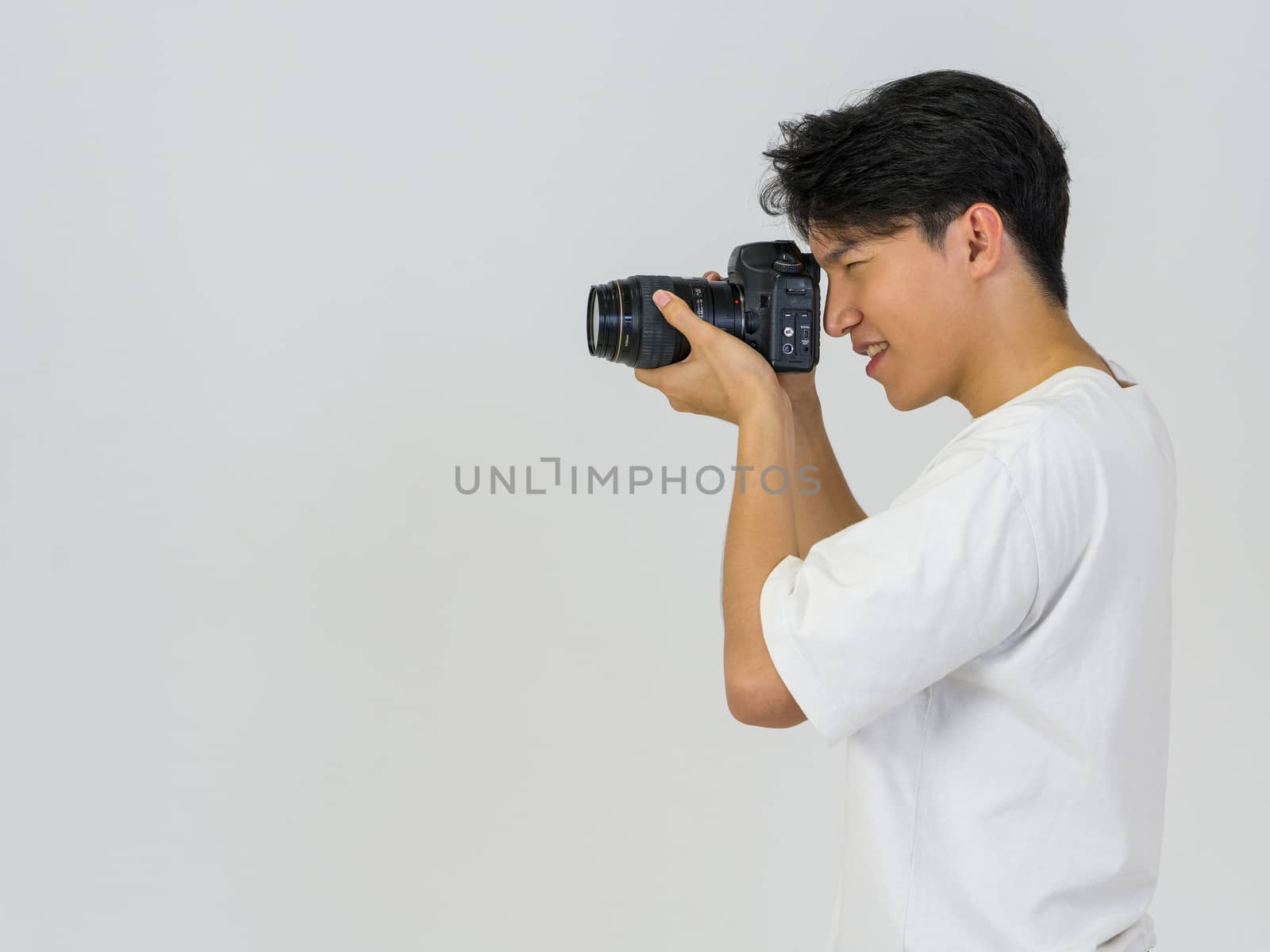The photographer looks through the viewfinder while shooting with the camera. Working atmosphere in the photo studio.