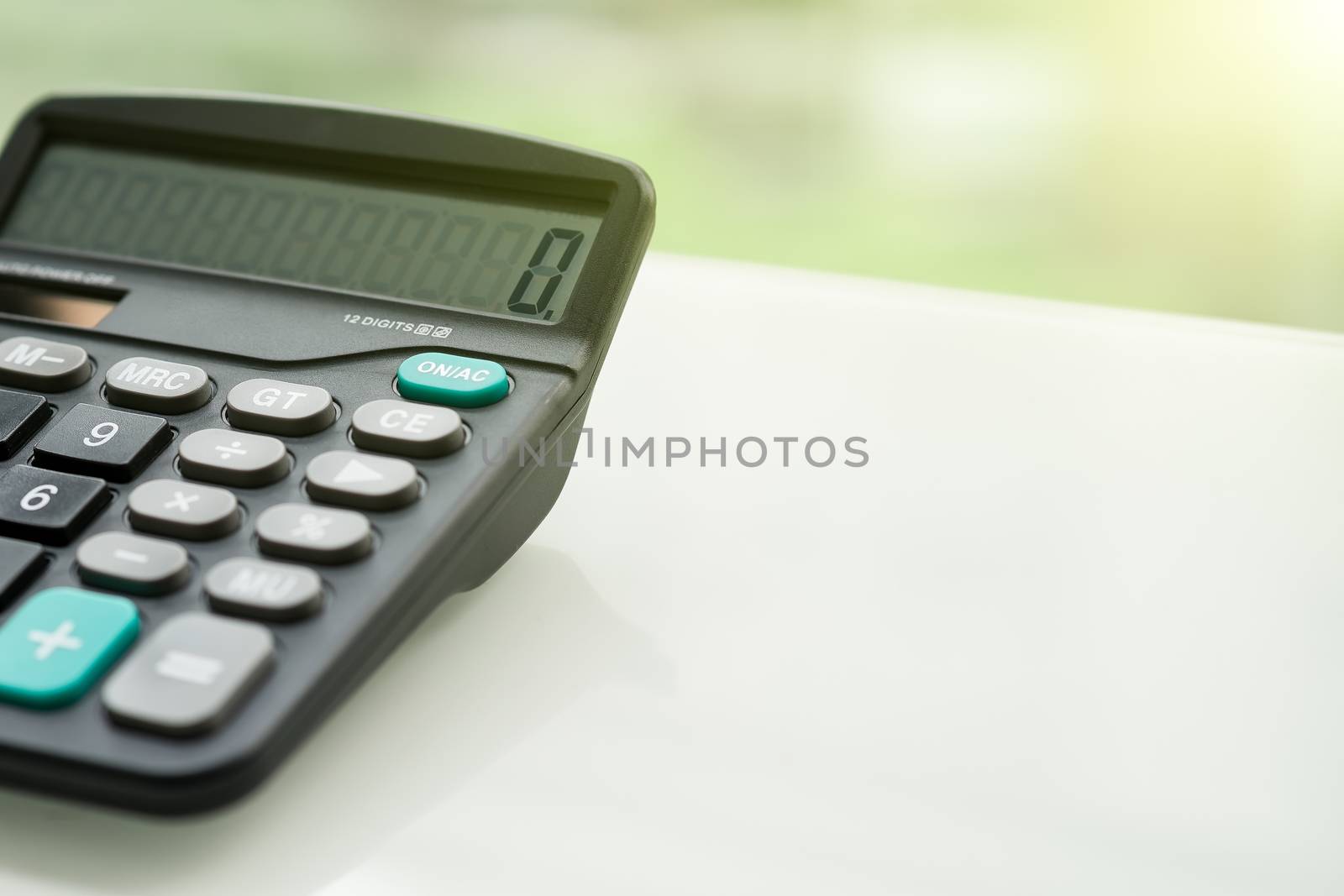 Calculator on the white table near window, closeup sideview isolated