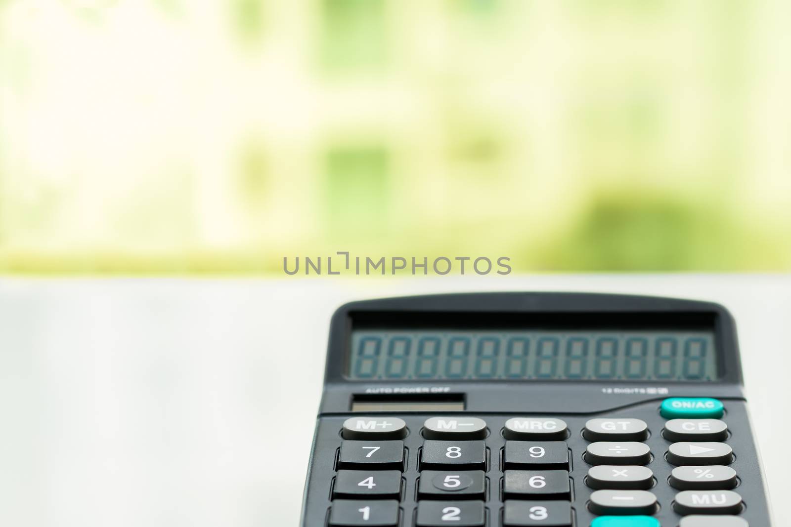 Calculator on the white table near window, closeup sideview isolated