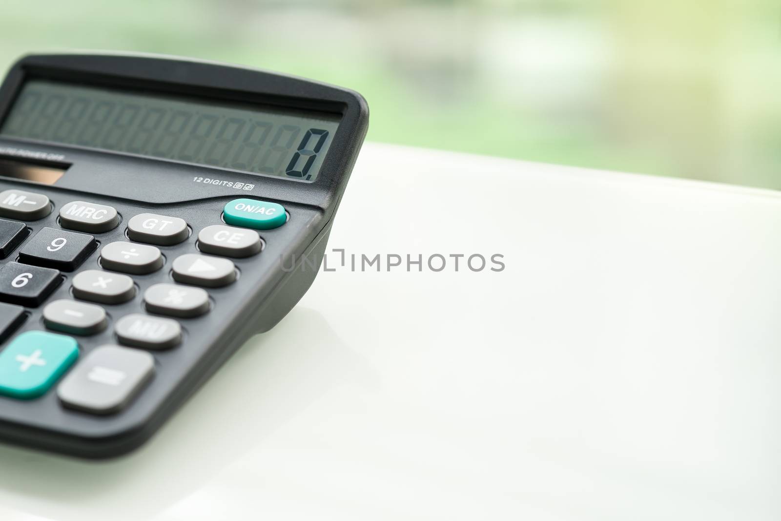 Calculator on the white table near window, closeup sideview isolated