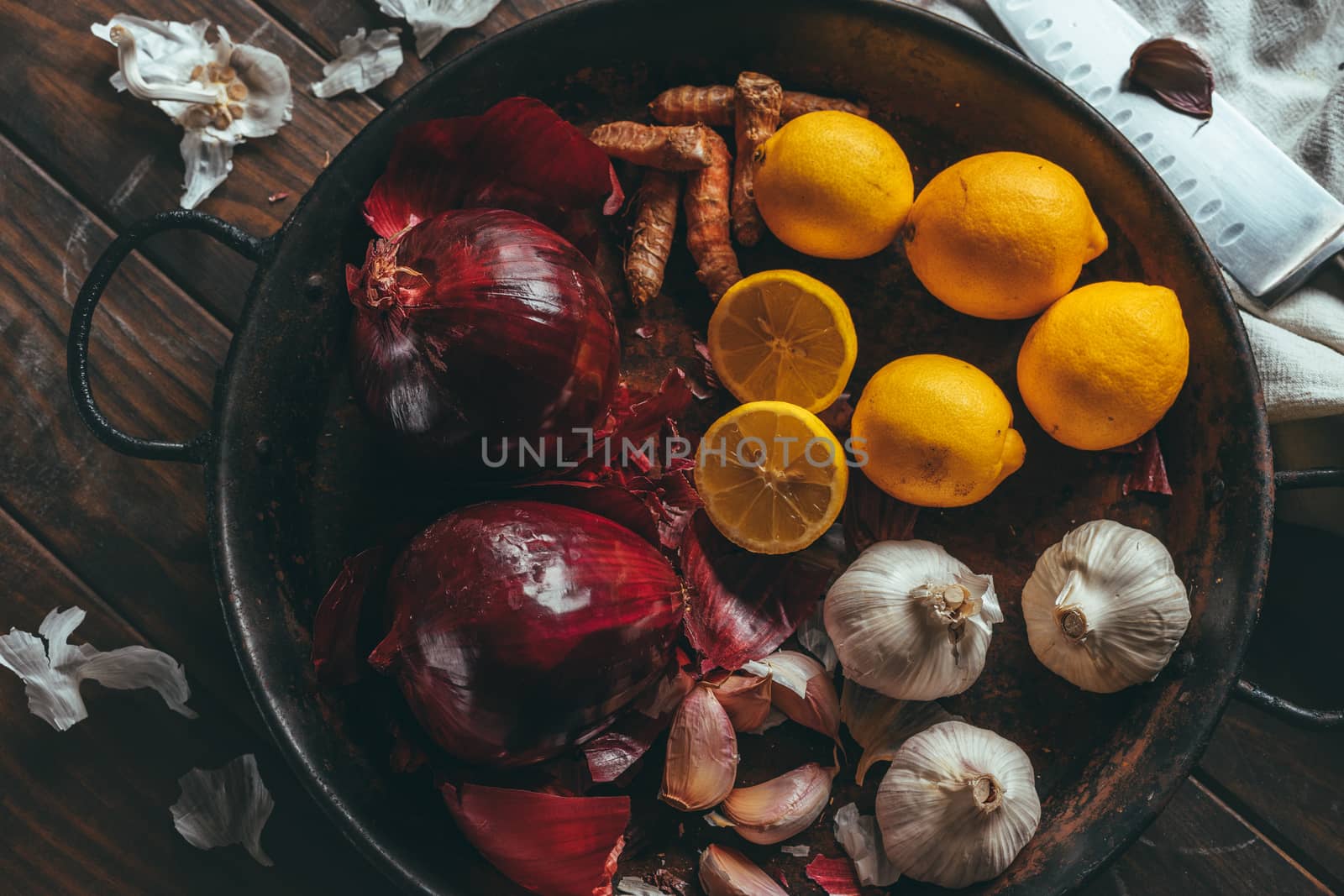 Paella with onion, turmeric, garlic and lemon on a wooden table in a rustic tone