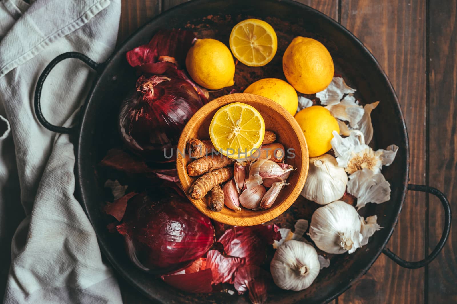 Paella with onion, turmeric, garlic and lemon on a wooden table in a rustic tone