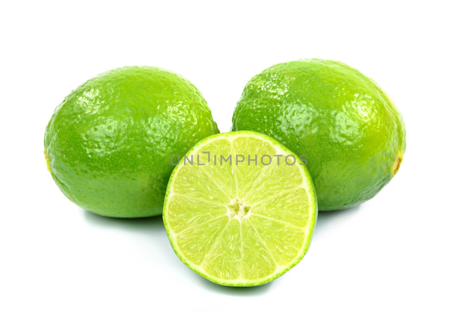 Fresh green halved lemon isolated on white background.