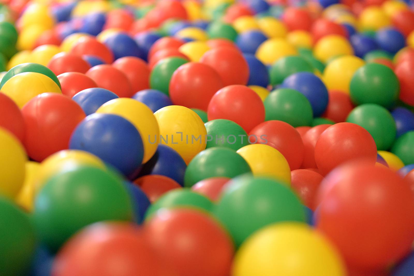 Multicolored background with plastic balls in children's play pool.