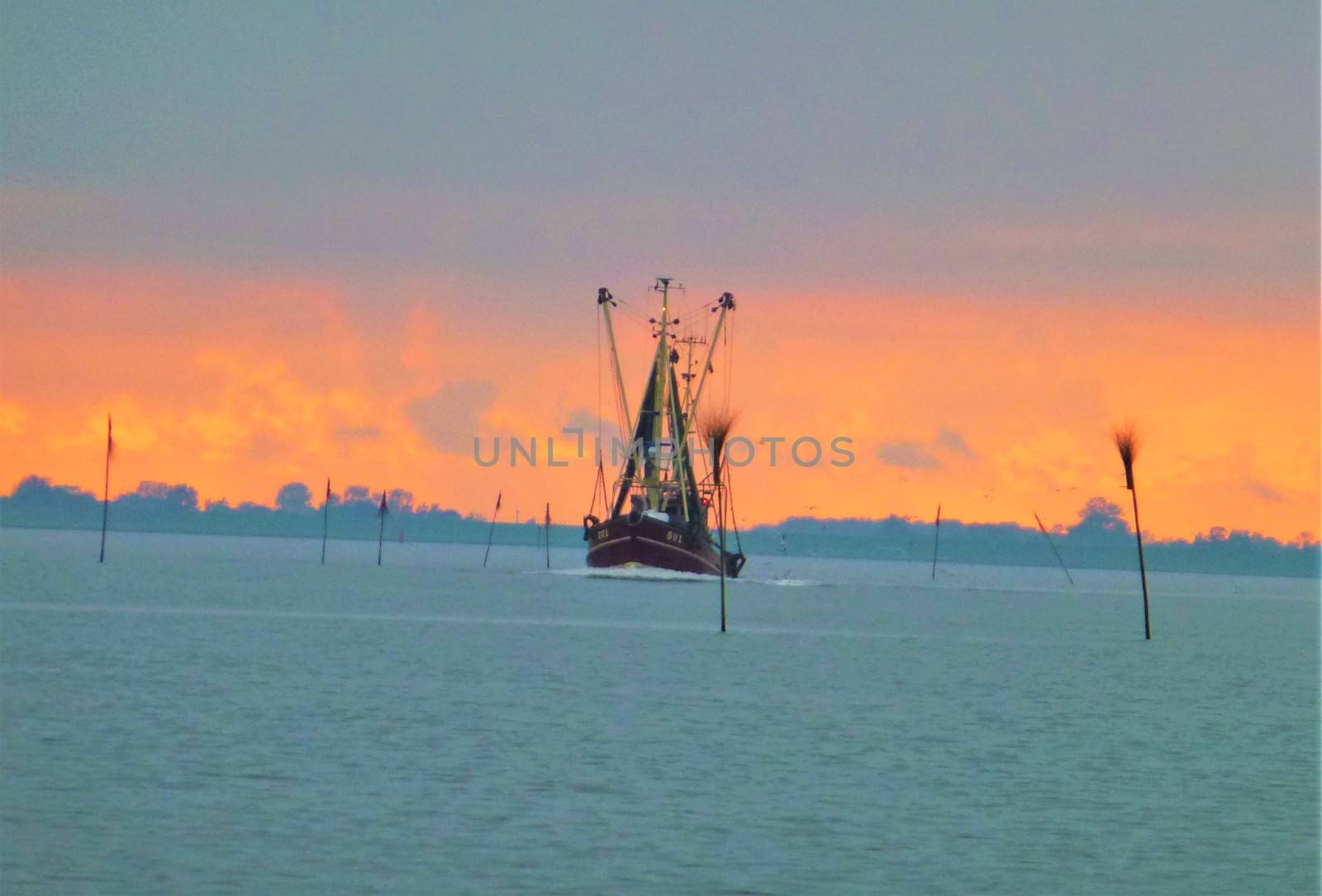 Photo of a ship in front of orange sky
