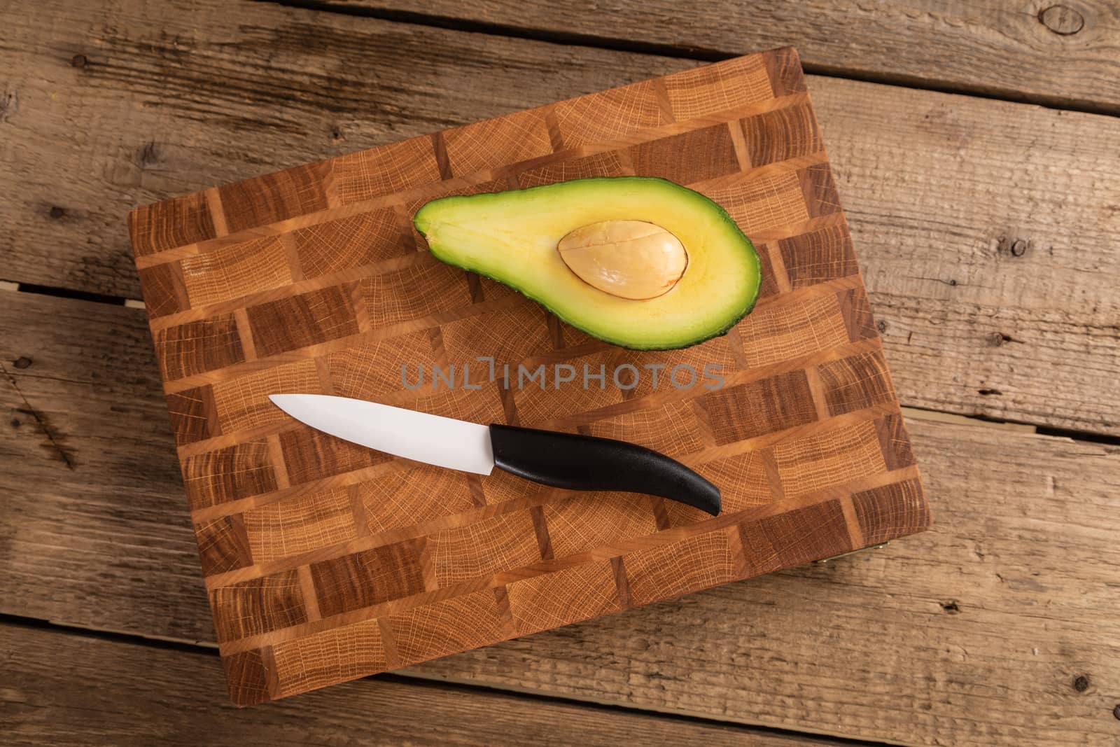 Avocado sliced with cube using knife on wooden cutting board