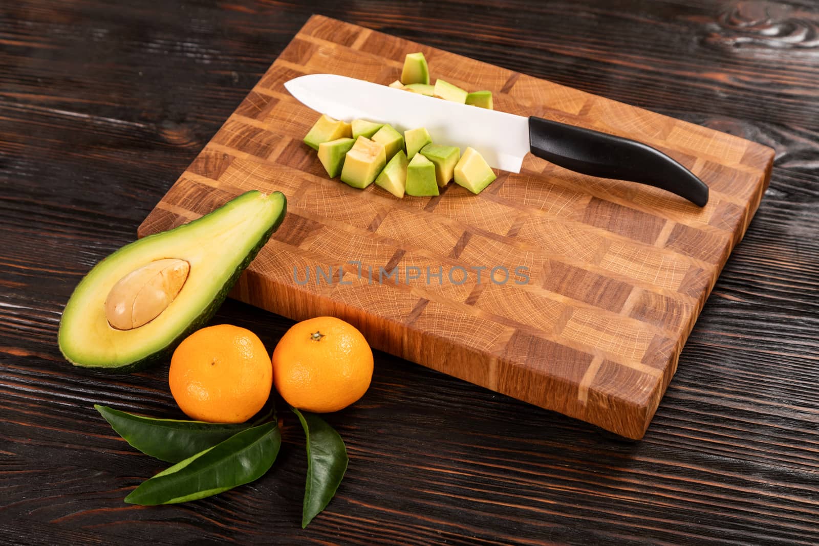 Avocado sliced with cube using knife on wooden cutting board