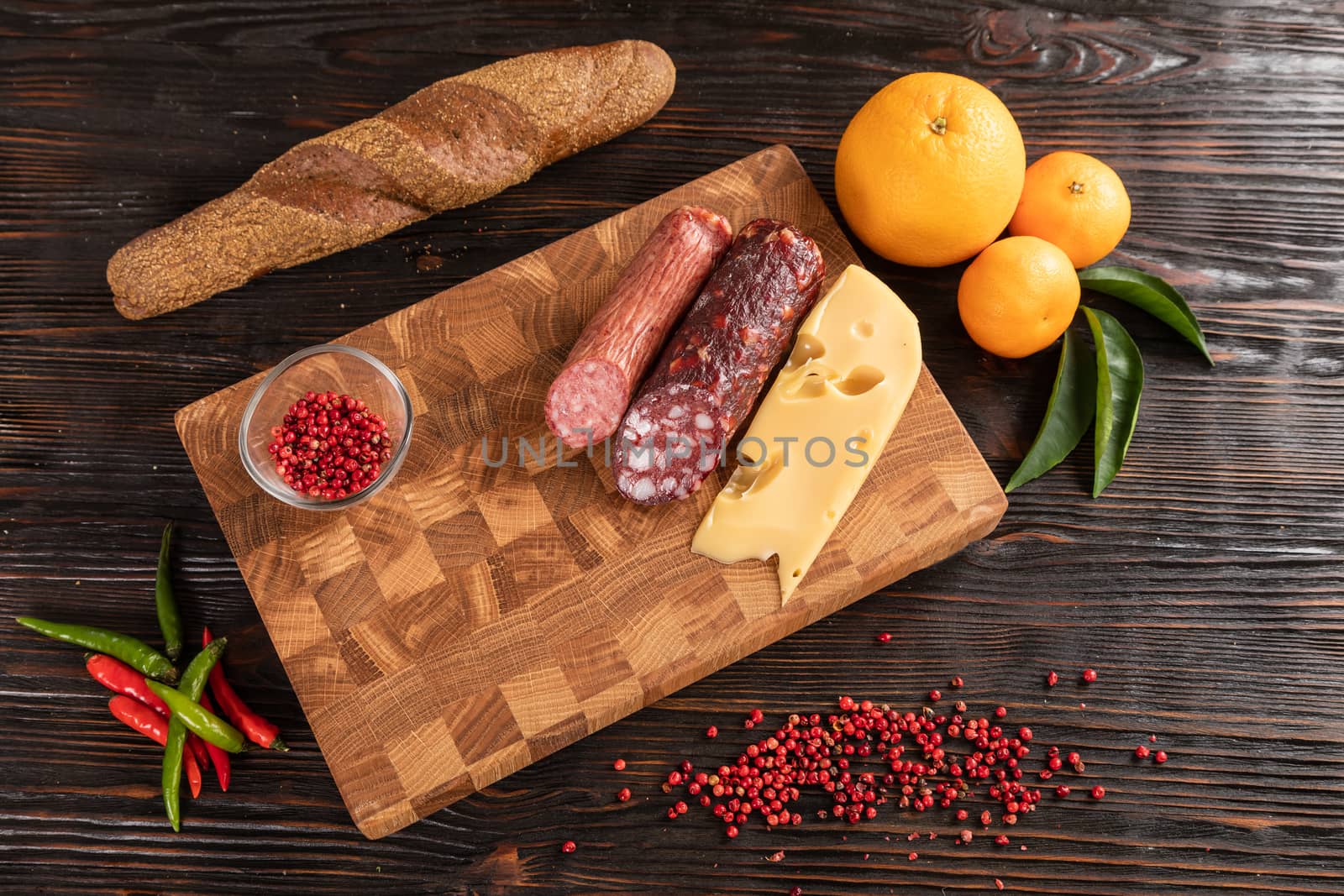 Sausage, cheese and bread on wooden cutting board