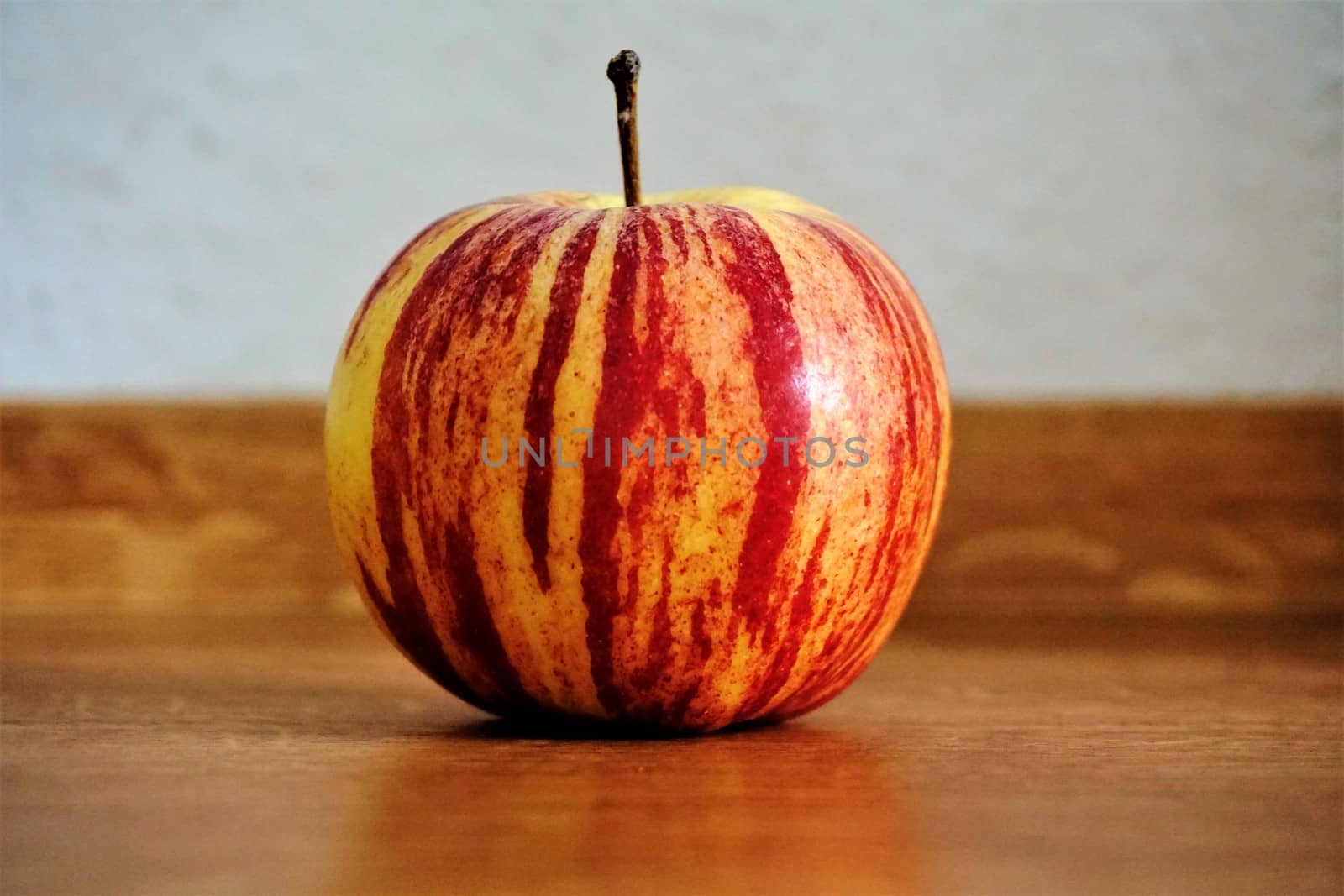 Photo of a single apple on a wooden table