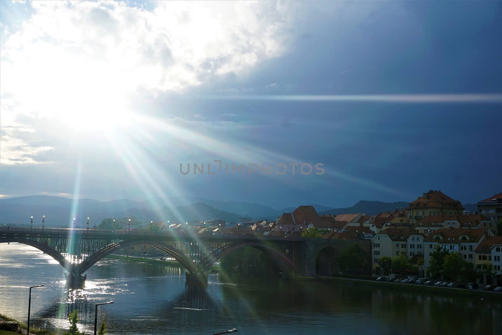 Sunrays over the city of Maribor on cloudy day