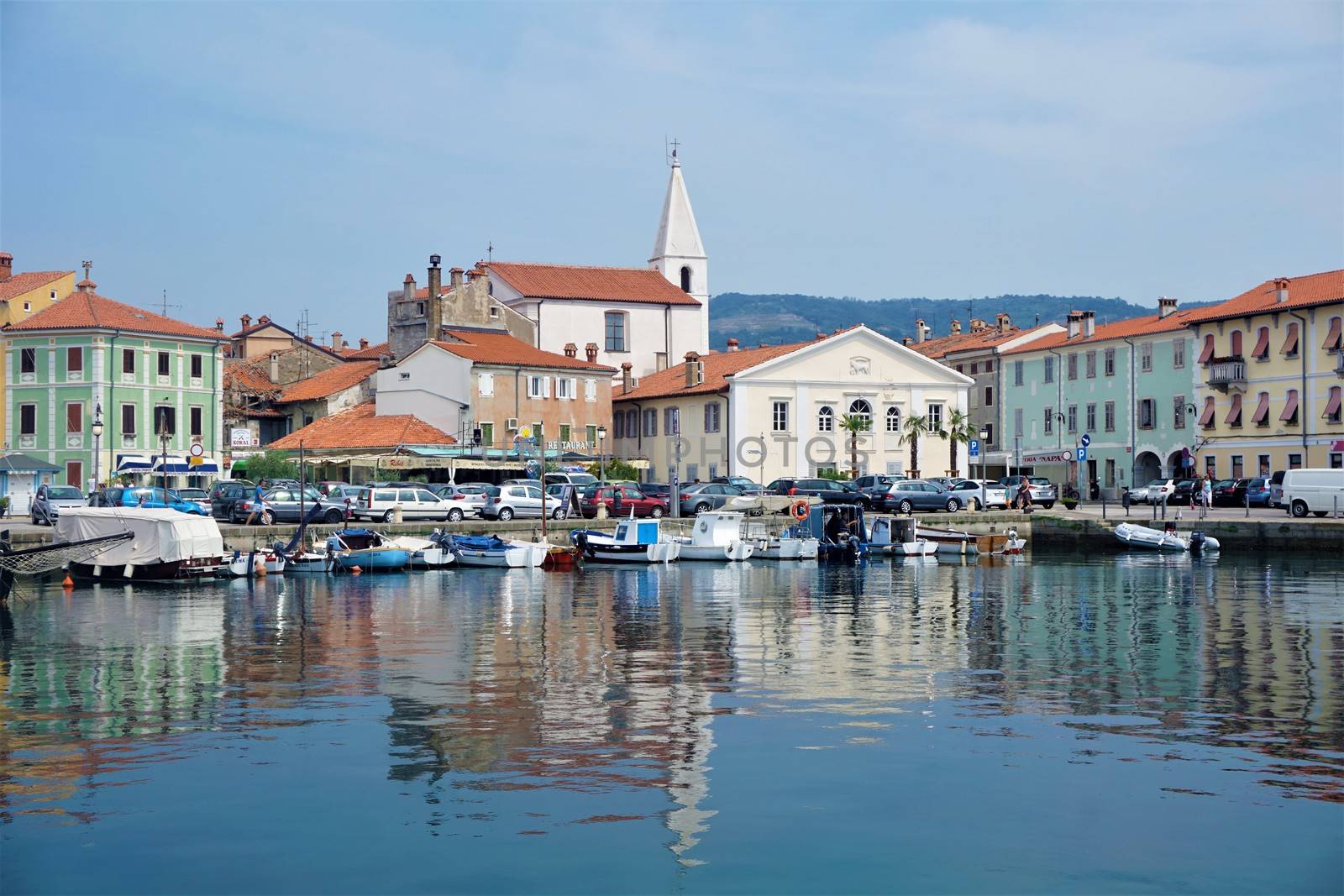 Small square with church and cars at the port of Izola by pisces2386