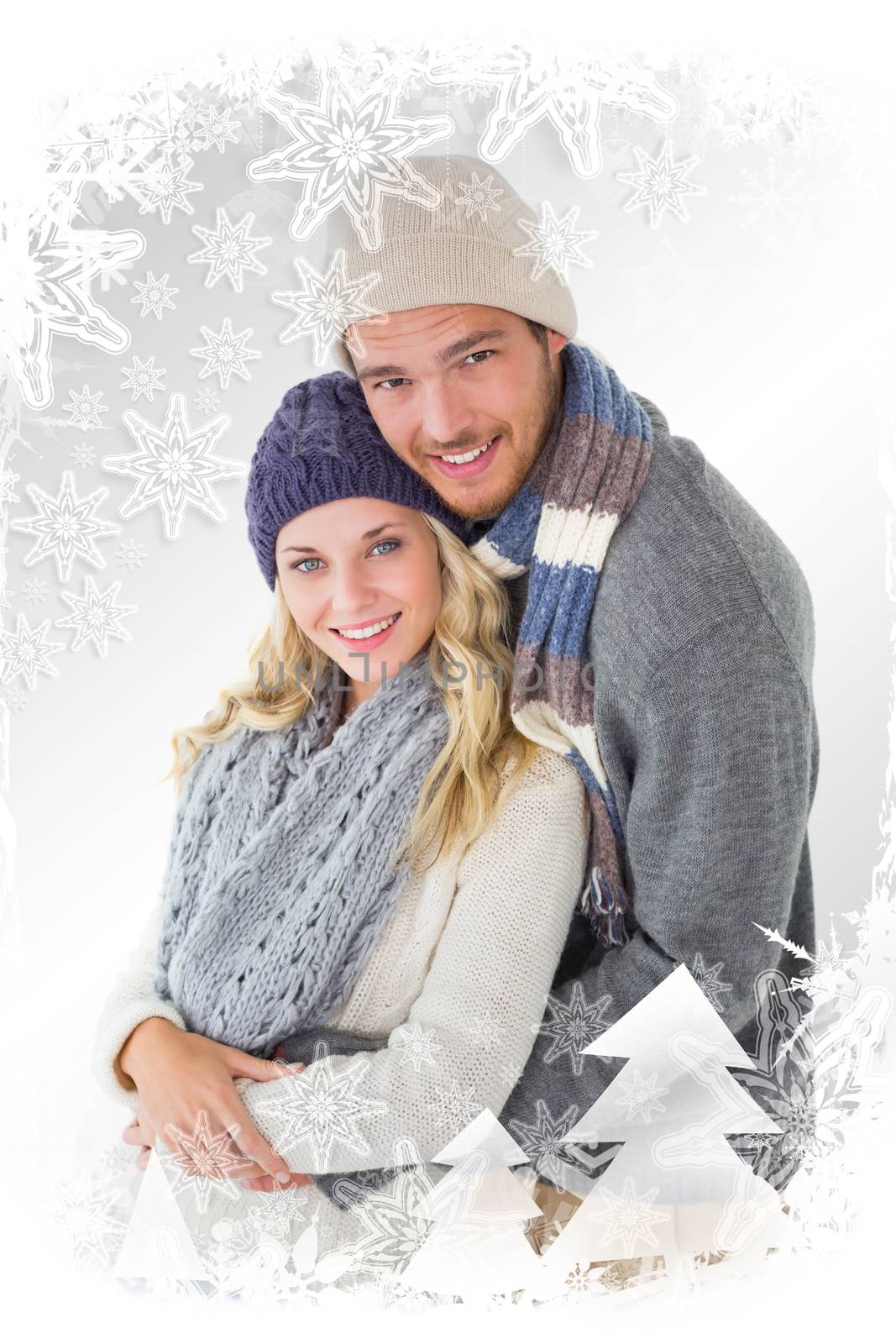 Attractive couple in winter fashion hugging against christmas frame