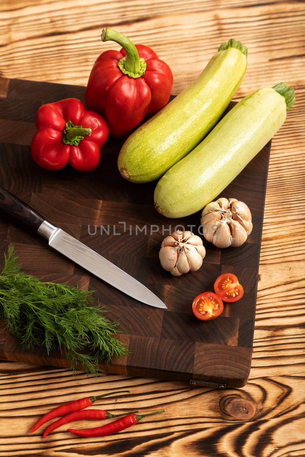 Fresh vegetables and greens on wooden cutting board