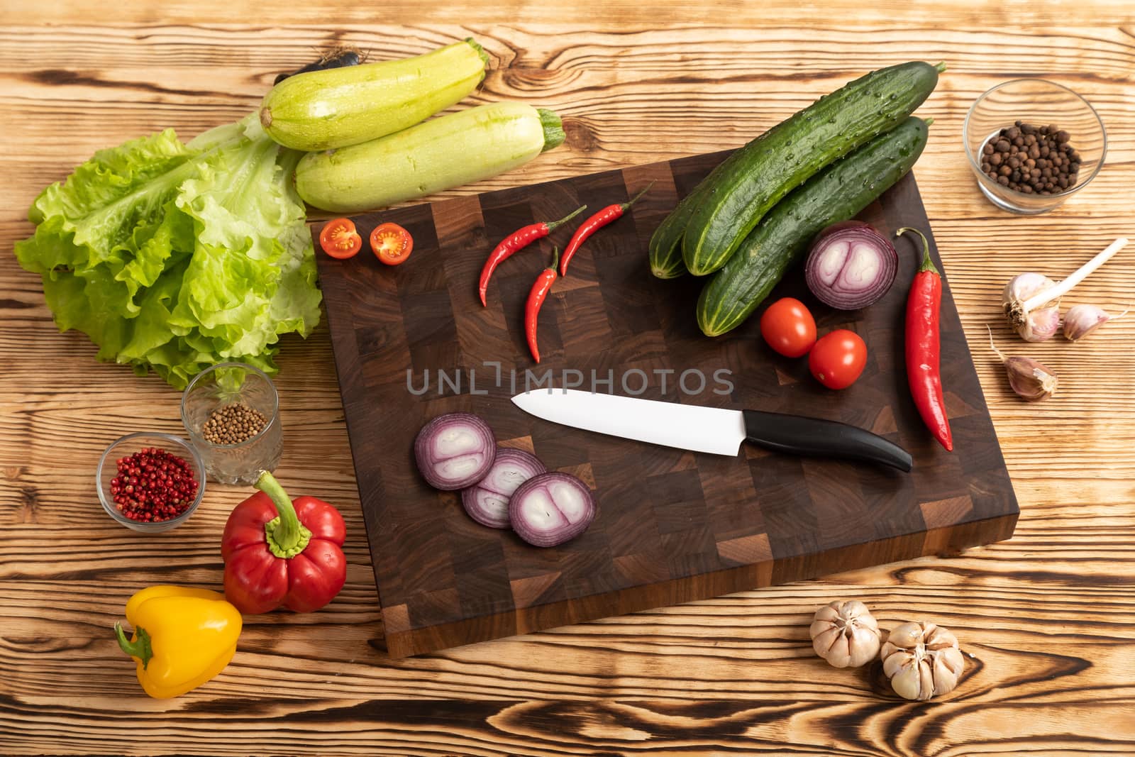 Fresh vegetables and greens on wooden cutting board