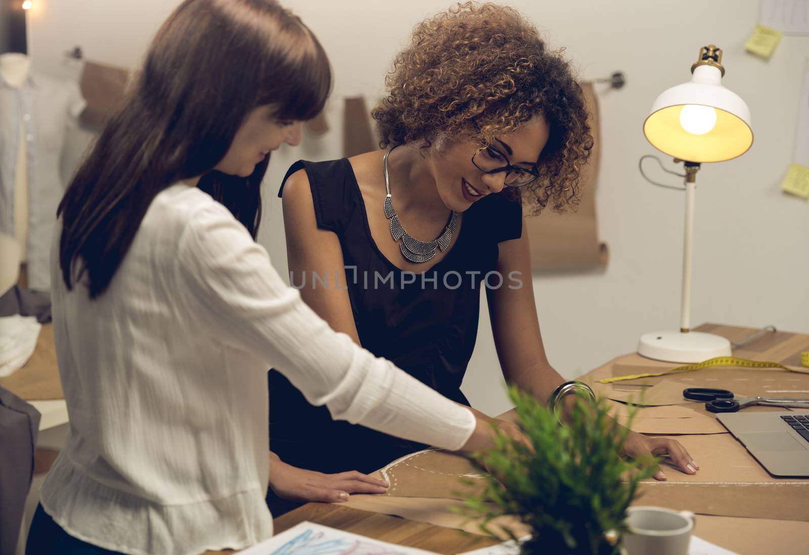 Two young entrepreneur women, and fashion designer working on her atelier