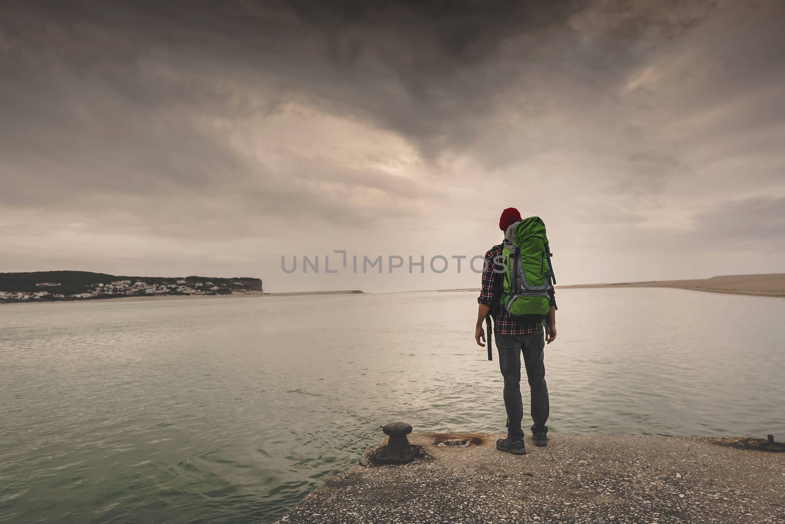 Man Traveling Backpack enjoying the beautiful view of the lake