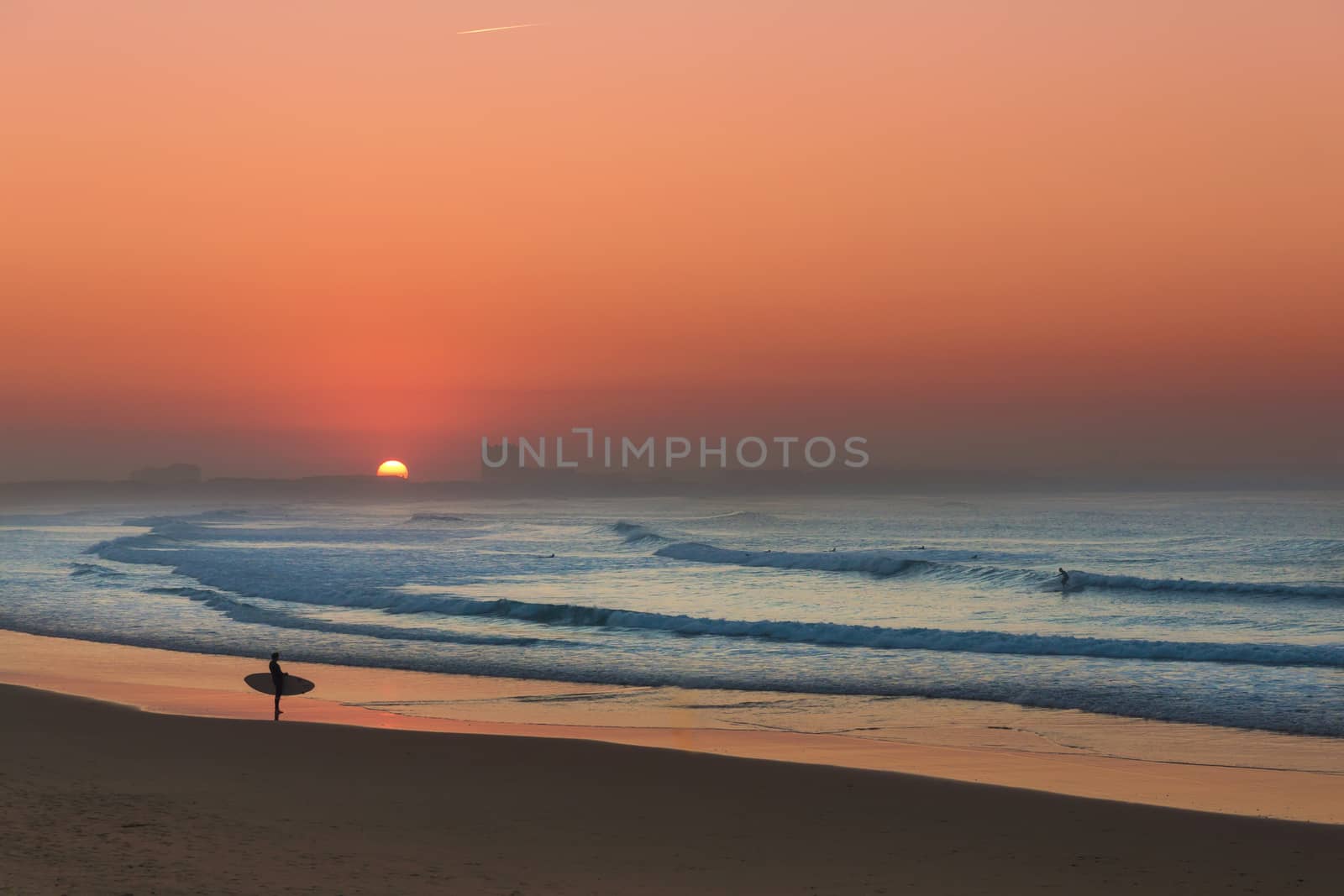 Surfer at sunset checking the waves