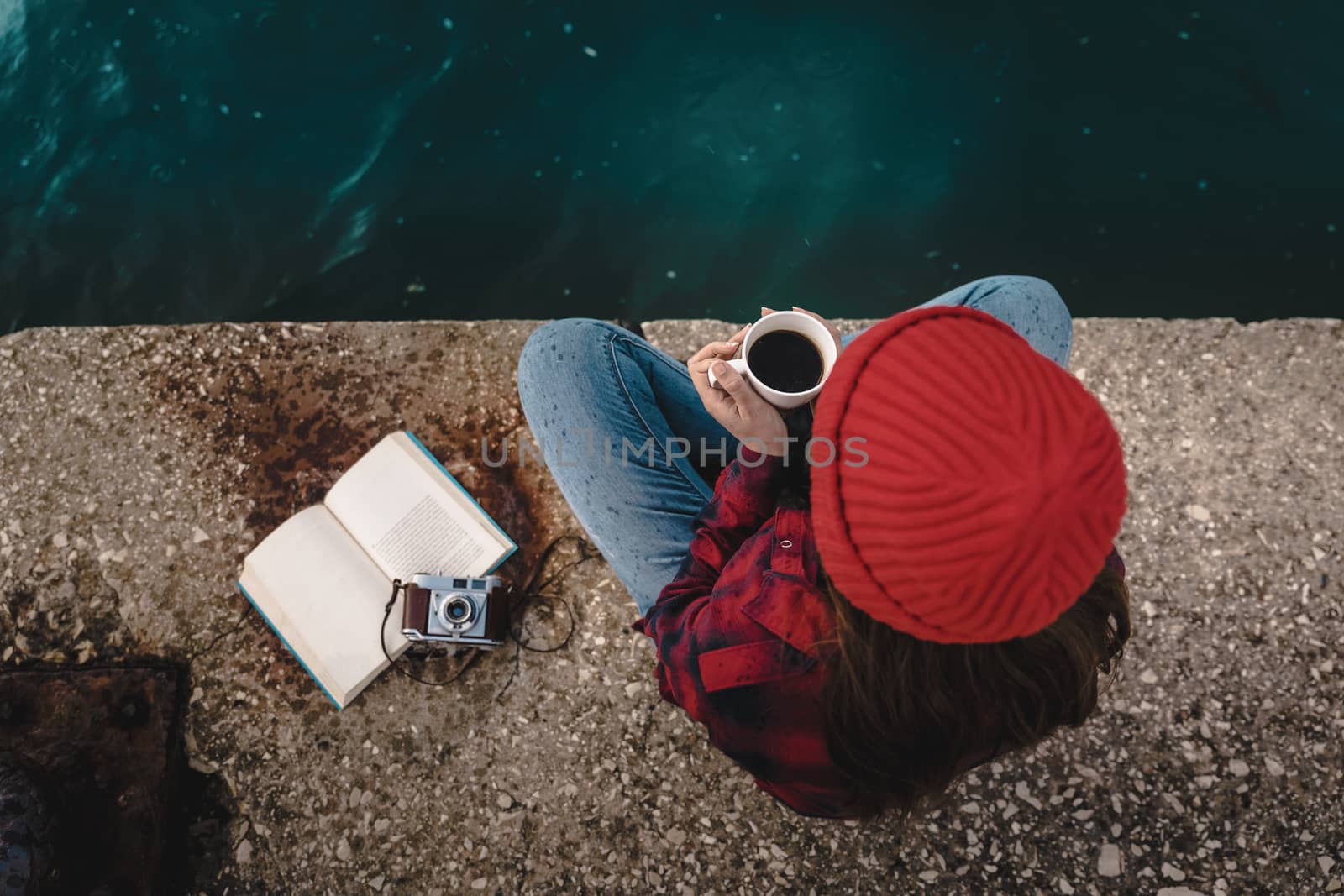 Beautiful woman enjoying her day in the lake with a mug of hot coffee