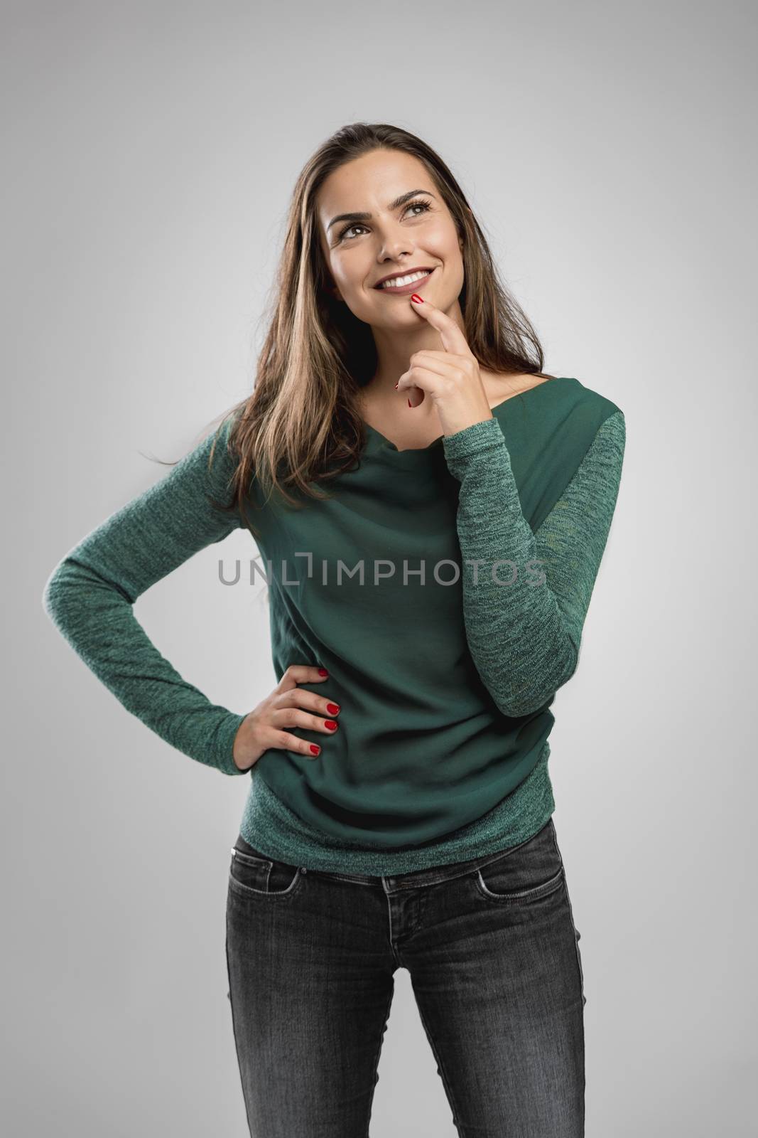 Beautiful woman smiling and with her hand on the chin thinking on something
