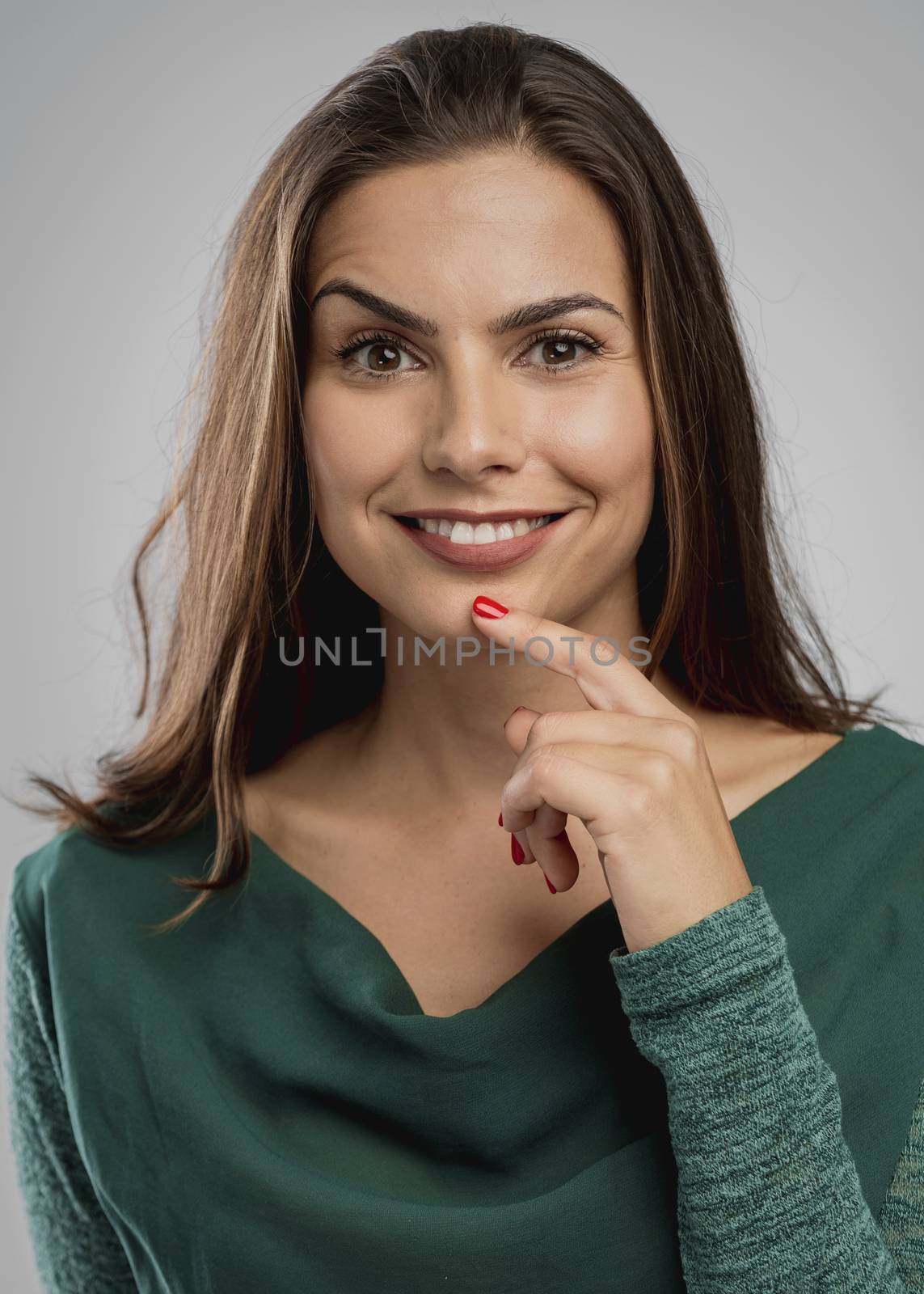 Portrait of a beautiful woman smiling and with her hand on the chin thinking on something