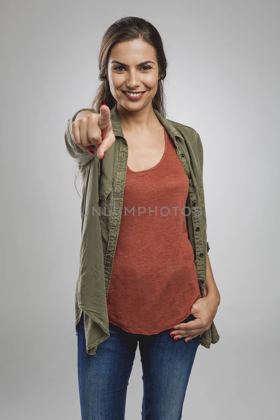 Beautiful happy woman looking and pointing with to the camera