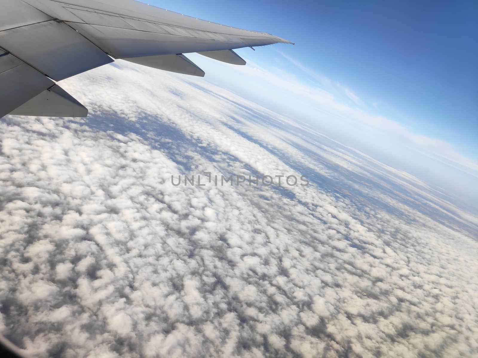 View outside plane window on wing and clouds by pisces2386