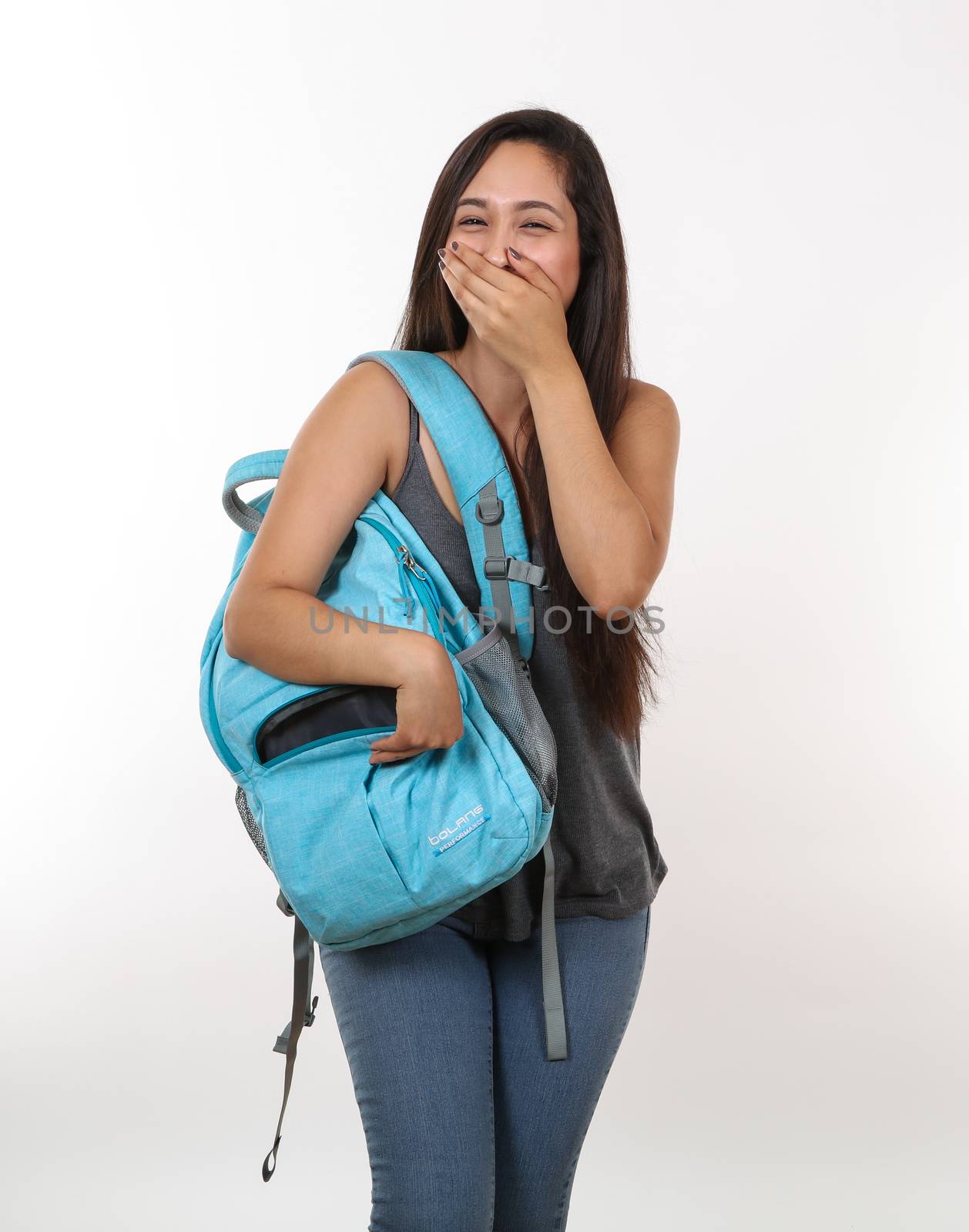 A young student laughs as she reaches for her backpack.